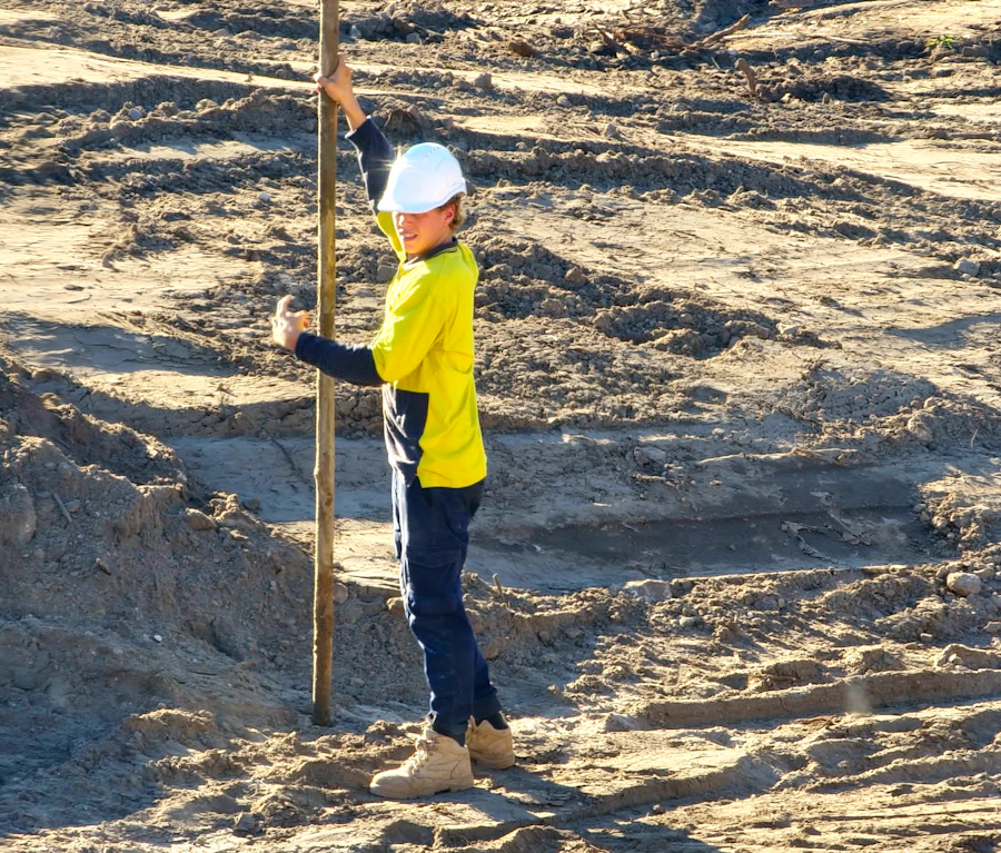 Tradesperson in hi-vis and hard hat on a job site