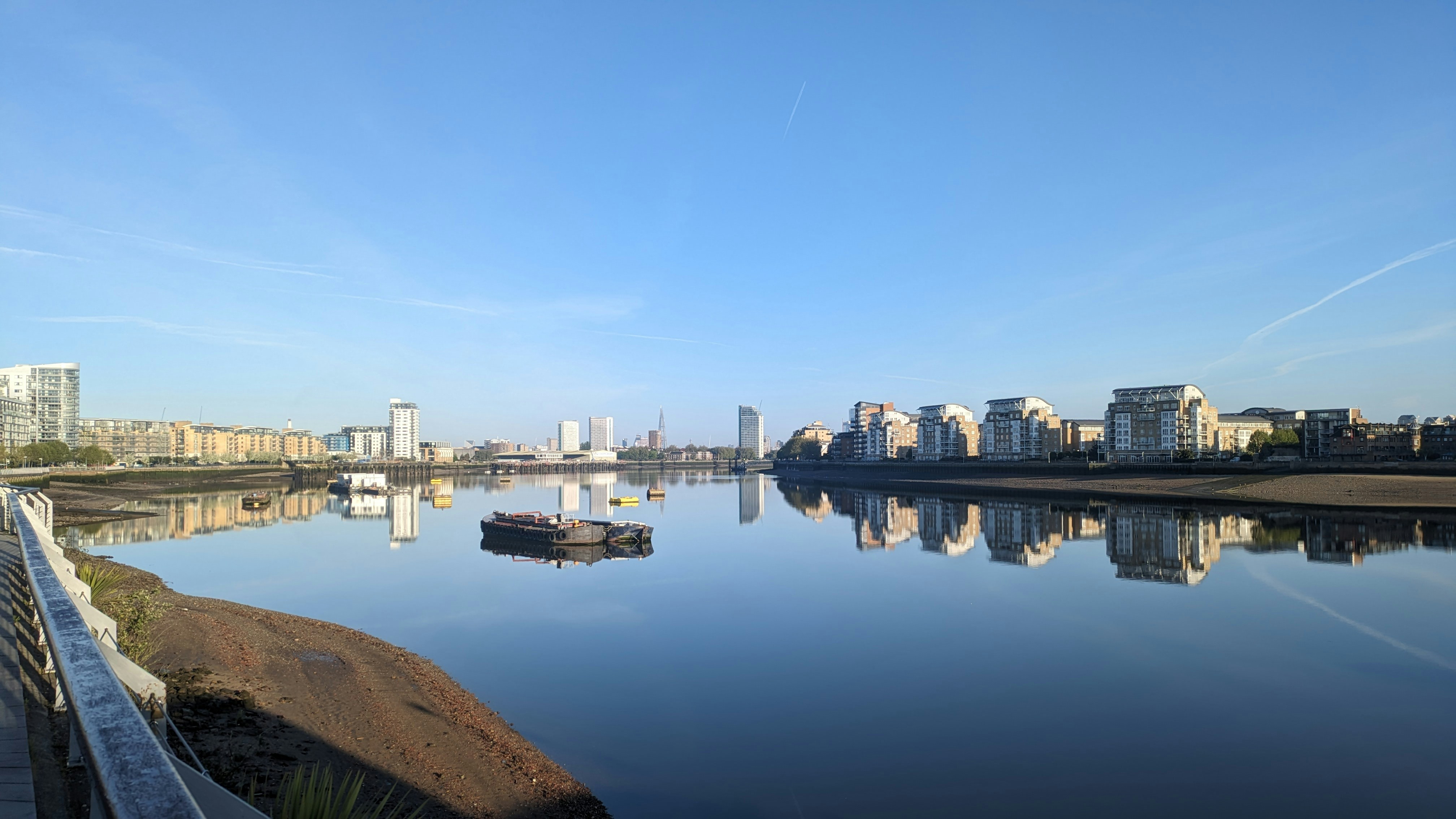 a boat floating on top of a lake next to tall buildings