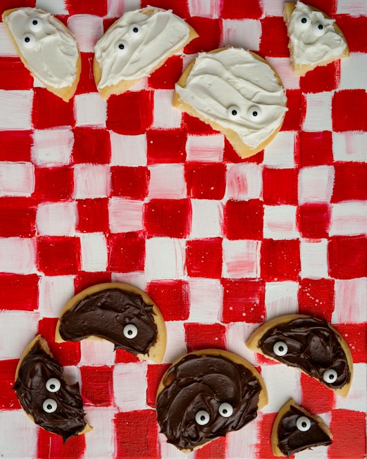 a checkered table cloth with cookies decorated like ghost faces