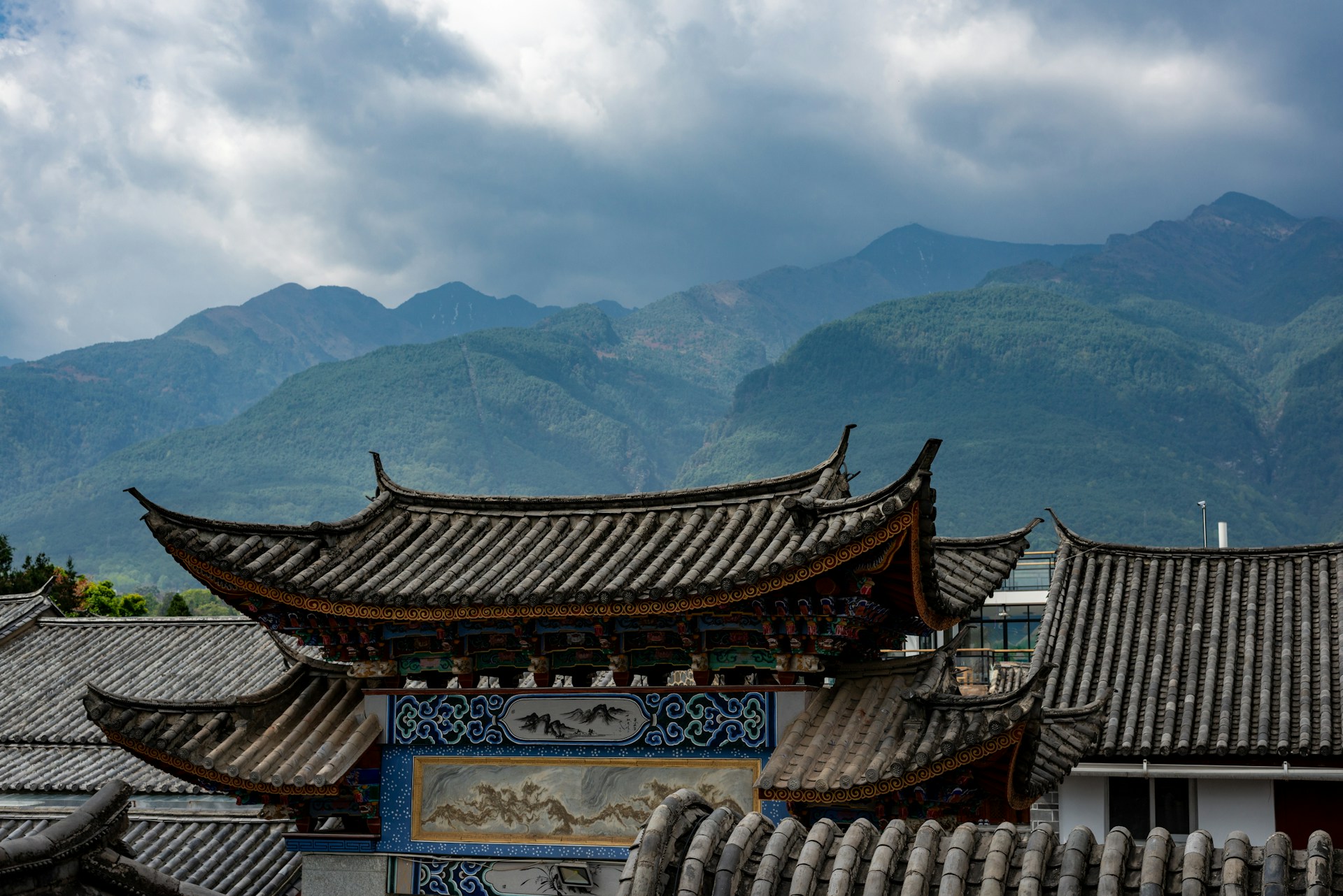 a chinese building with mountains in the background