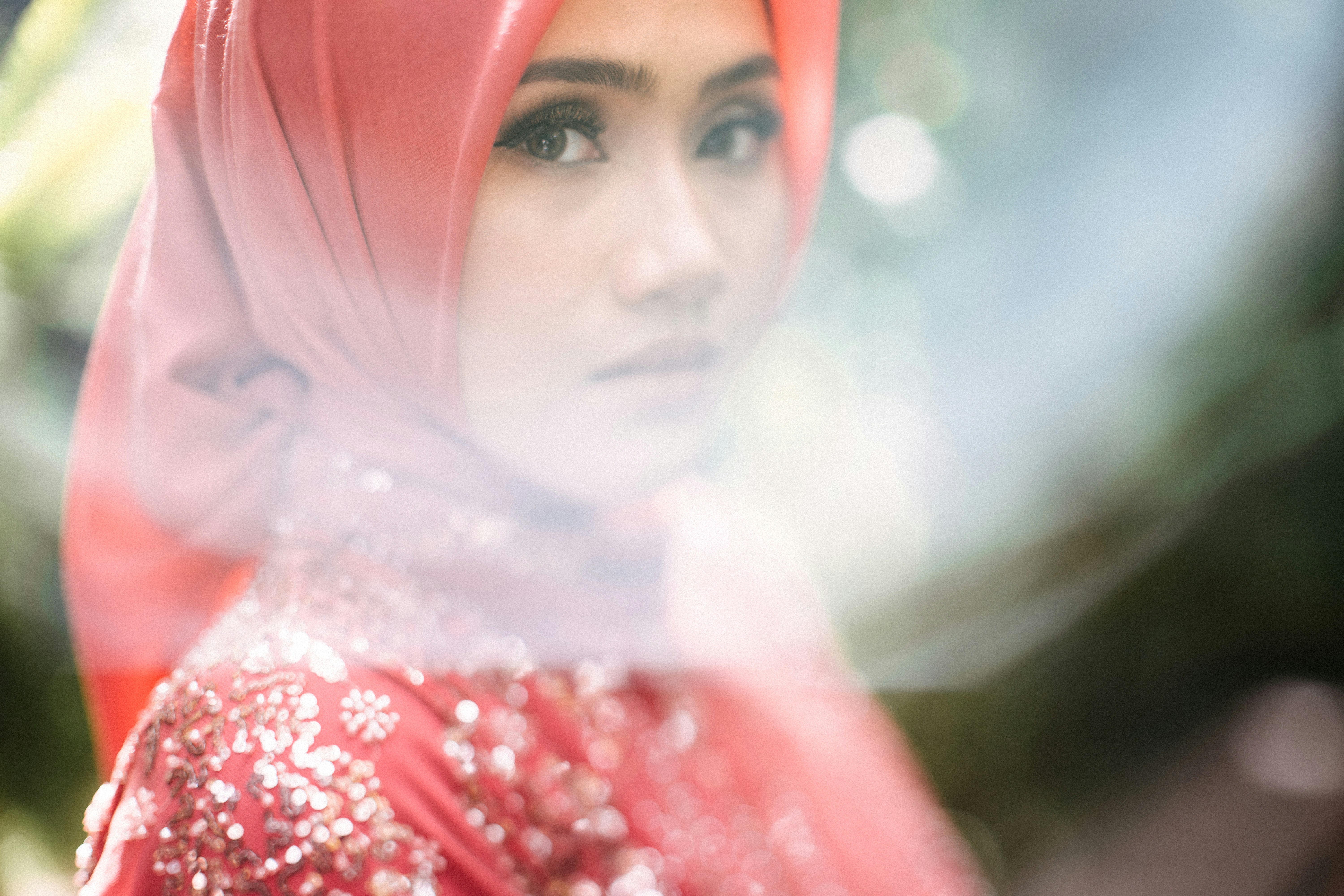 a woman in a red hijab looking at the camera