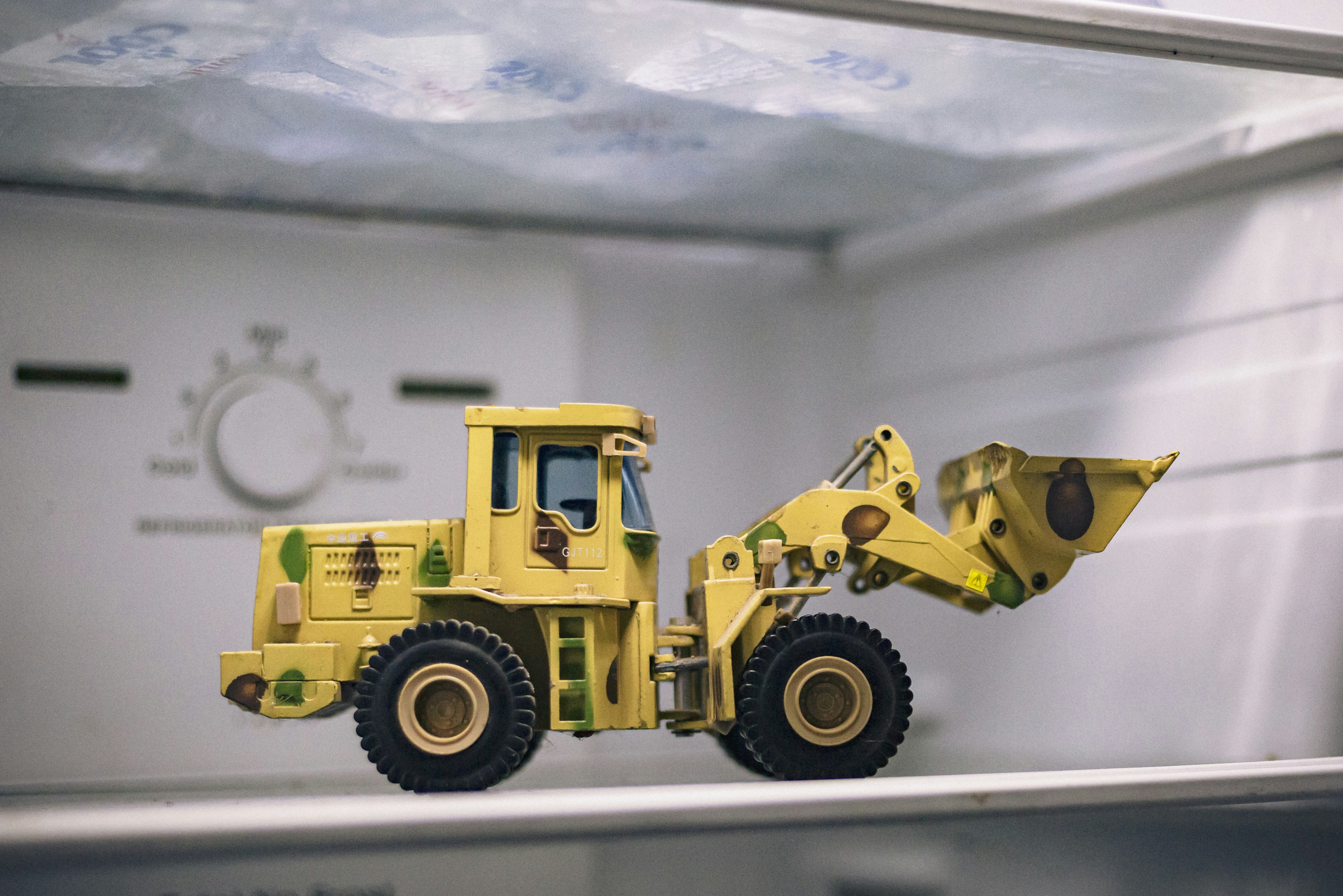 a yellow toy truck sitting on top of a shelf