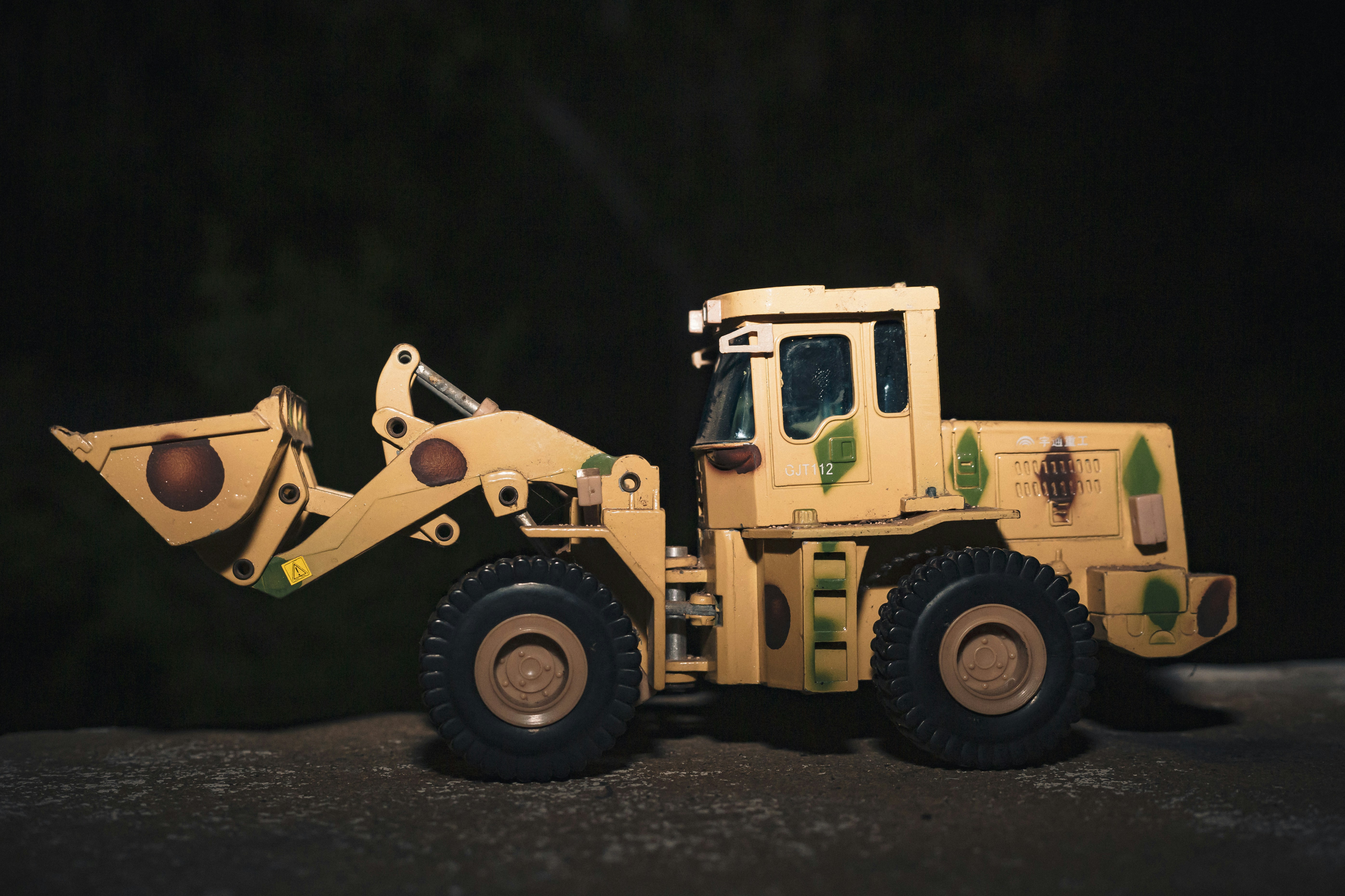 a yellow toy truck with a shovel on top of it