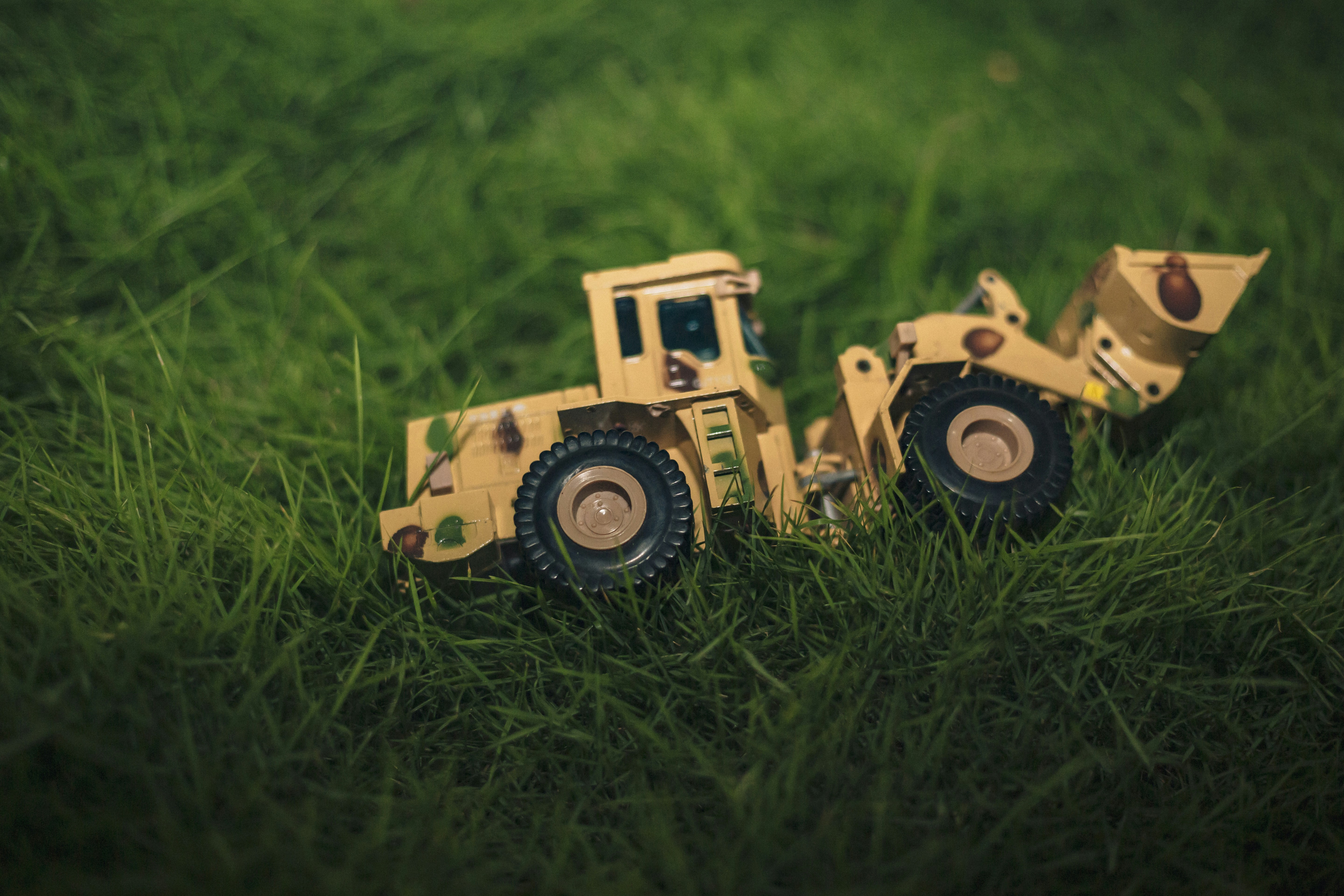 a couple of toy trucks sitting on top of a lush green field