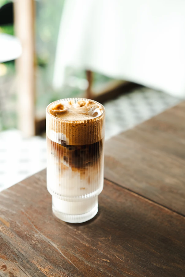 a cup of coffee sitting on top of a wooden table