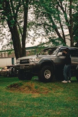 A man standing next to a truck in a yard
