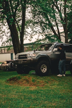 A man standing next to a truck in a yard