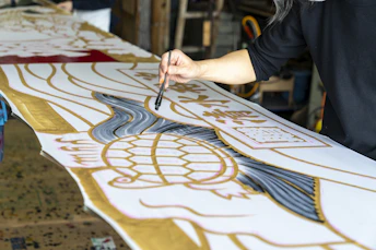 a woman is working on a large piece of art