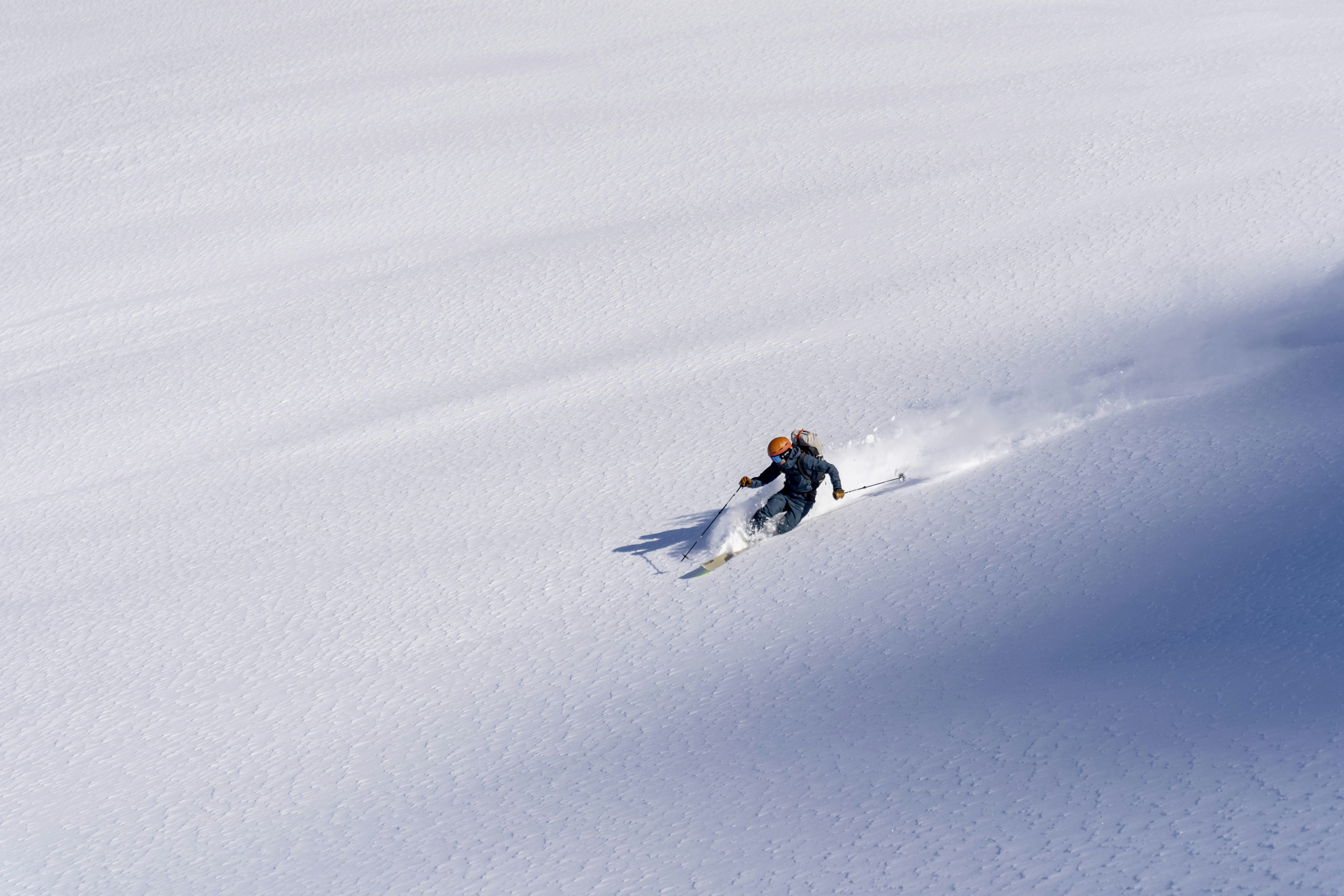 a man riding skis down a snow covered slope