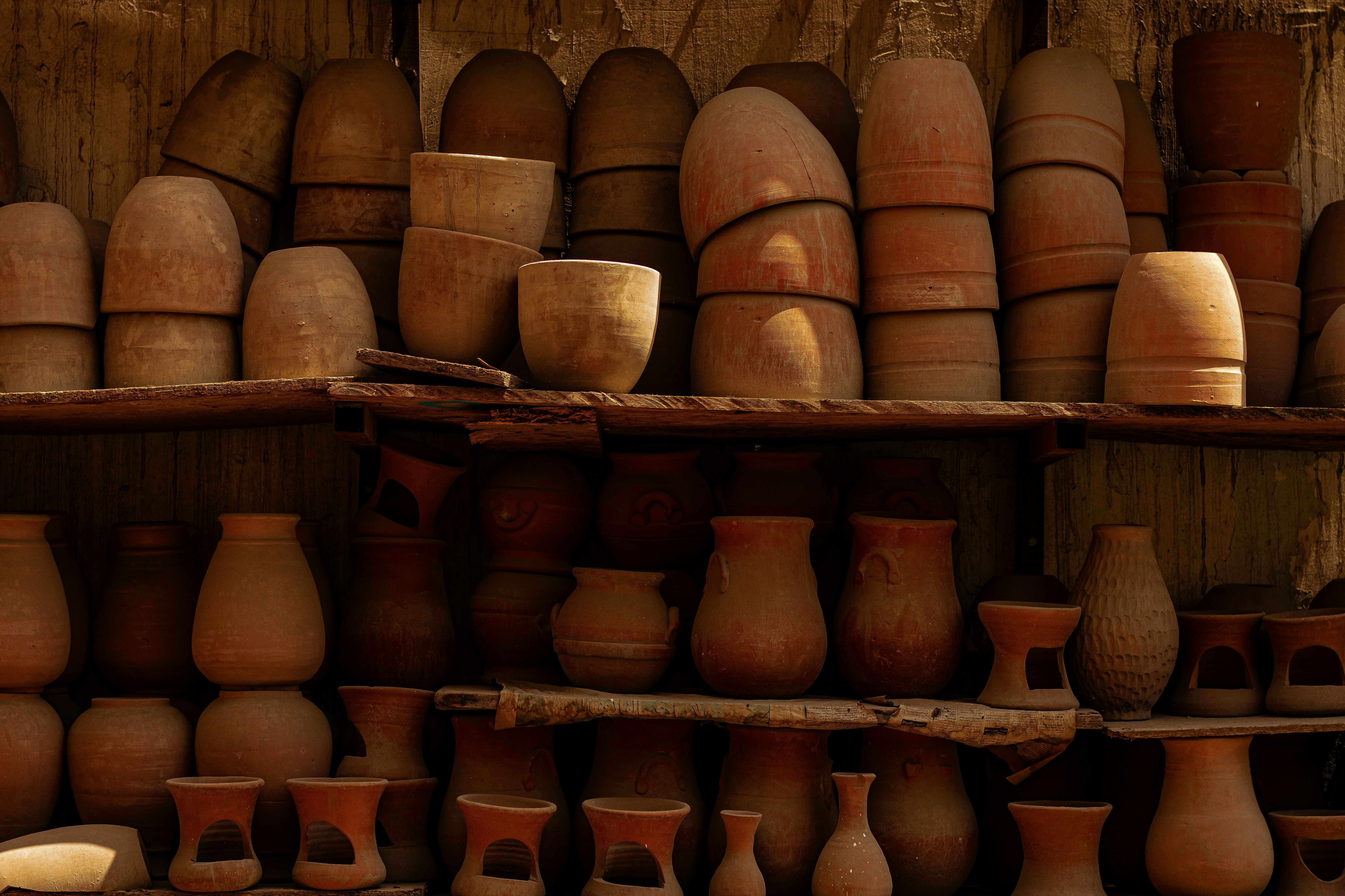 a shelf filled with lots of clay pots