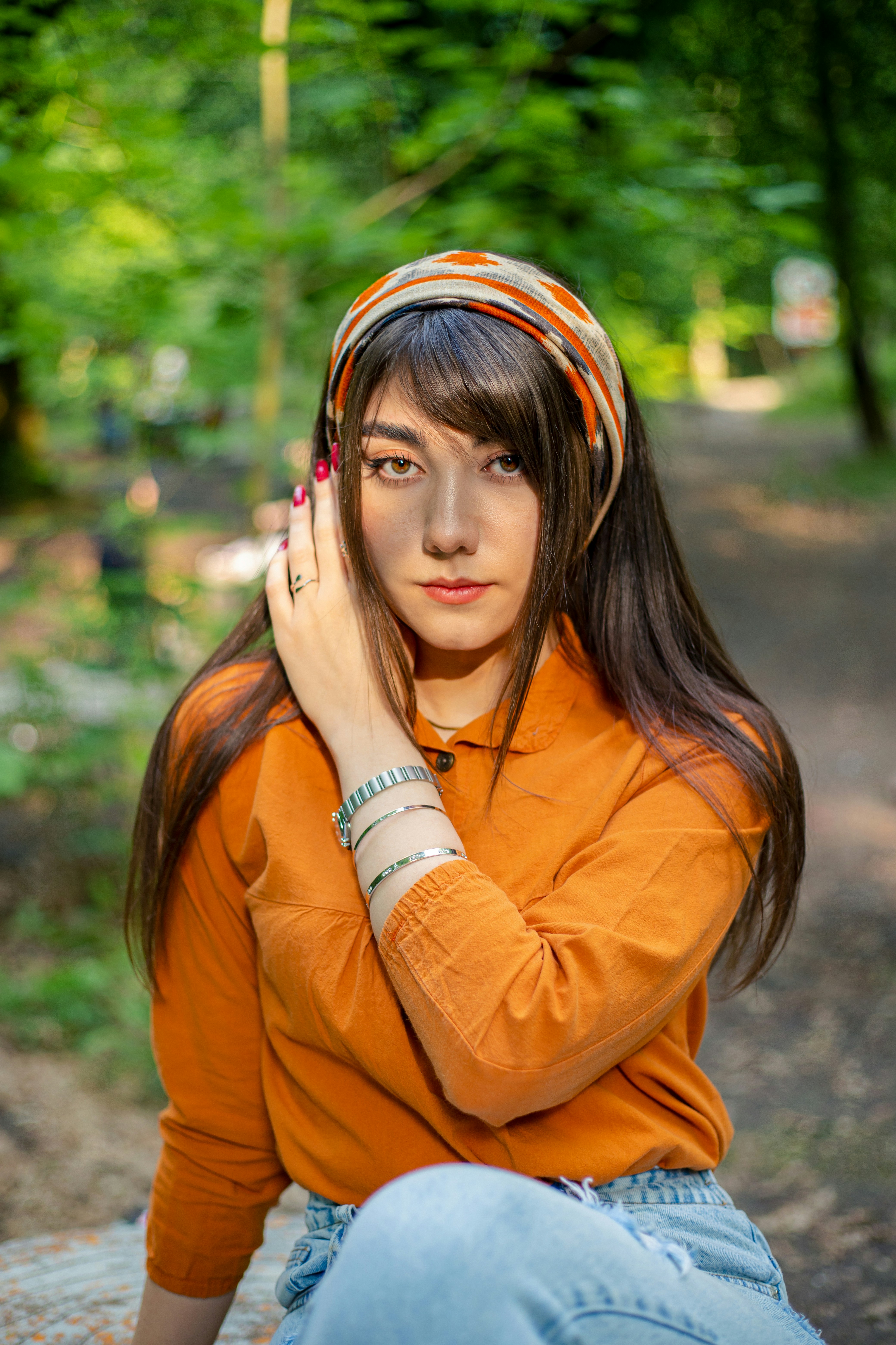 a woman sitting on a rock in the woods
