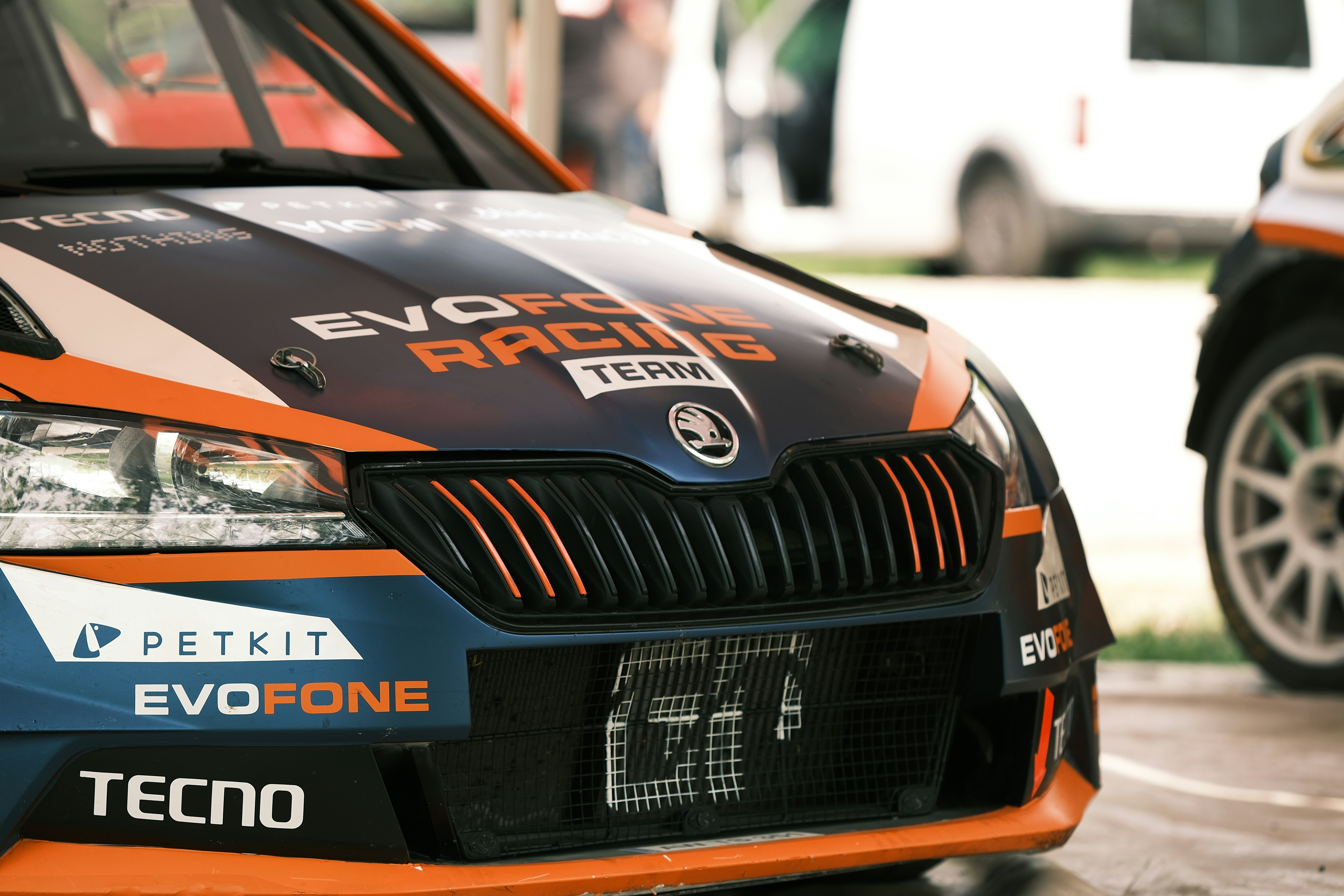 an orange and blue car parked in a parking lot