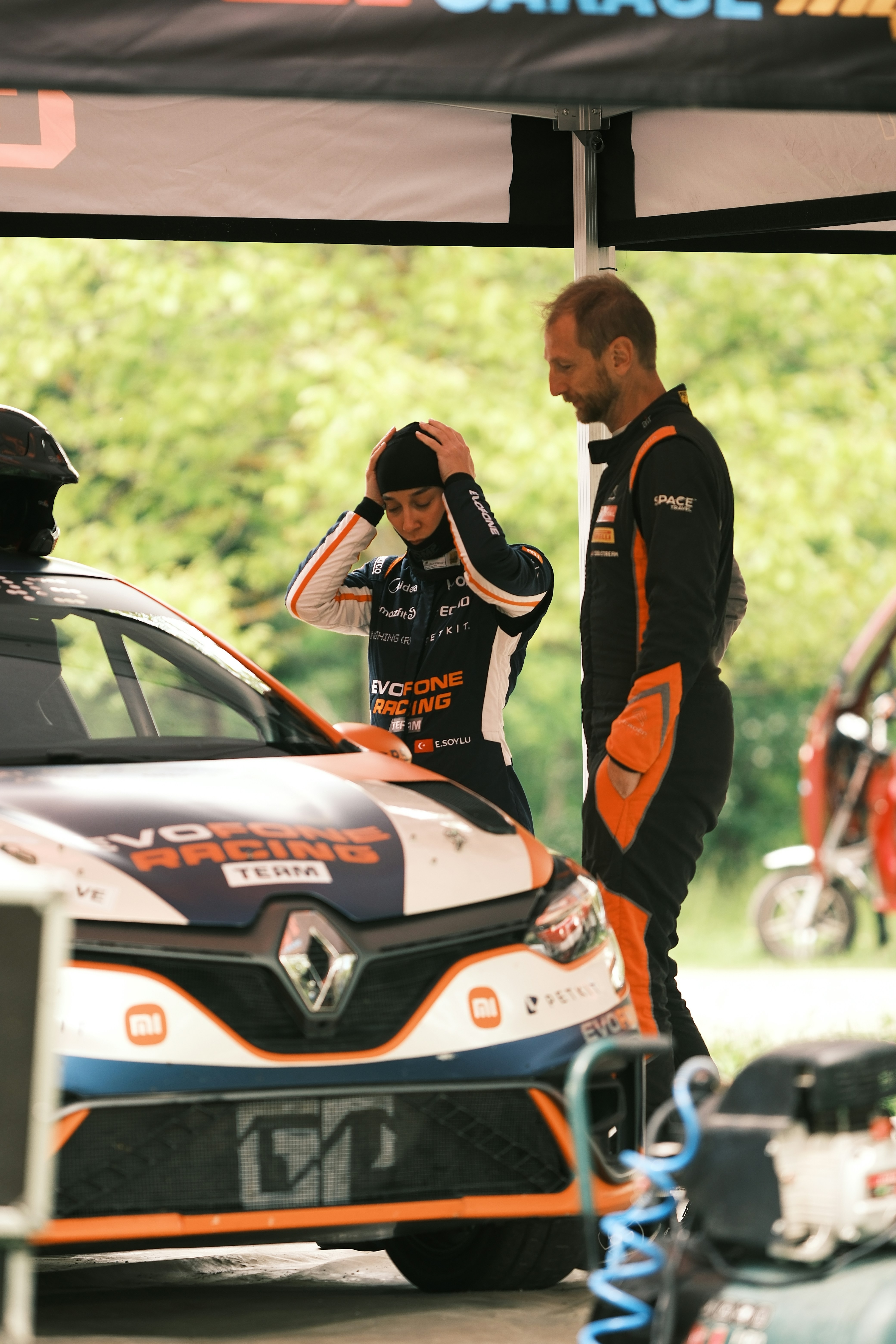 a couple of men standing next to a car