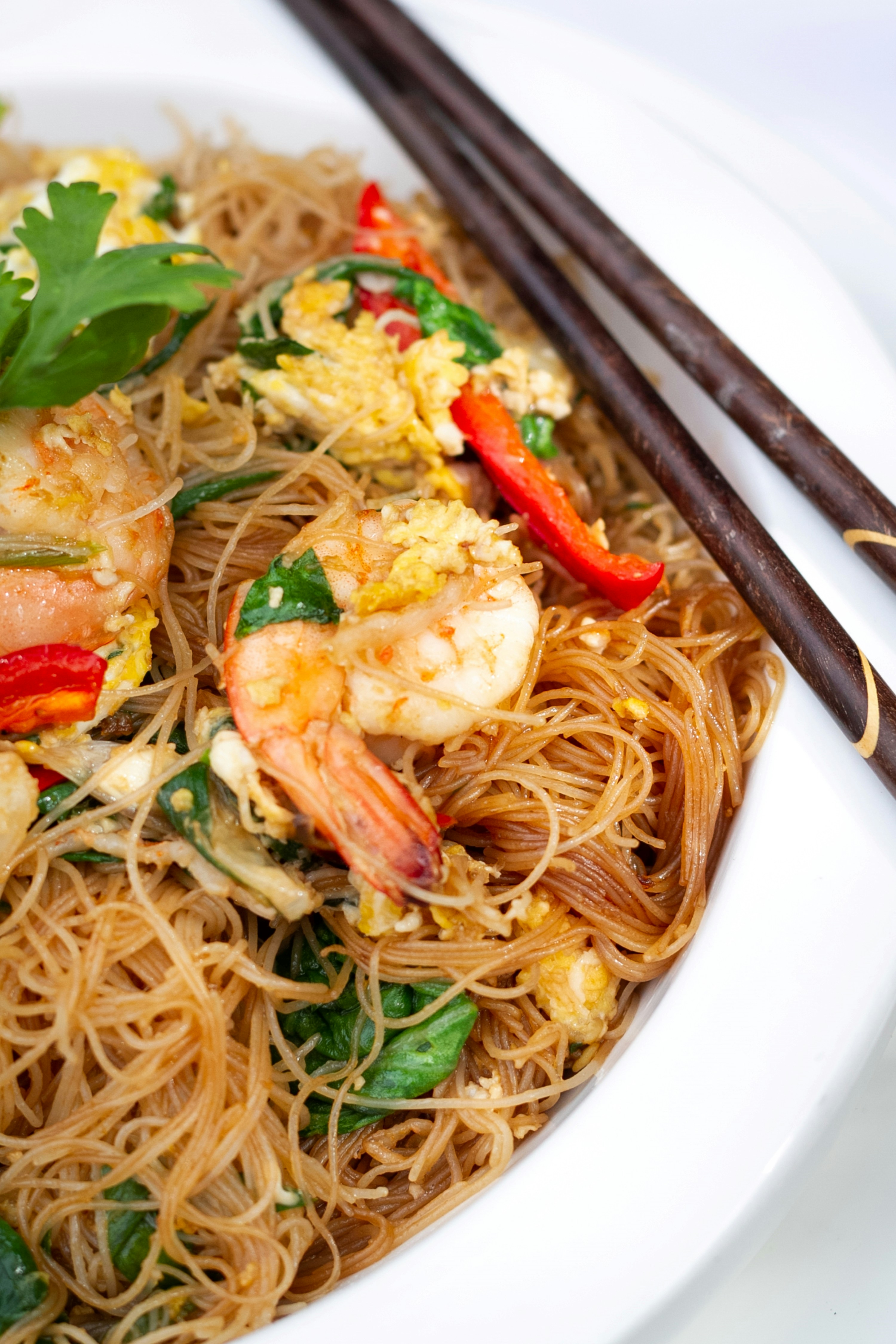 a white plate topped with noodles and shrimp