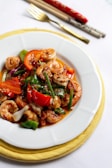 a white plate topped with shrimp and veggies
