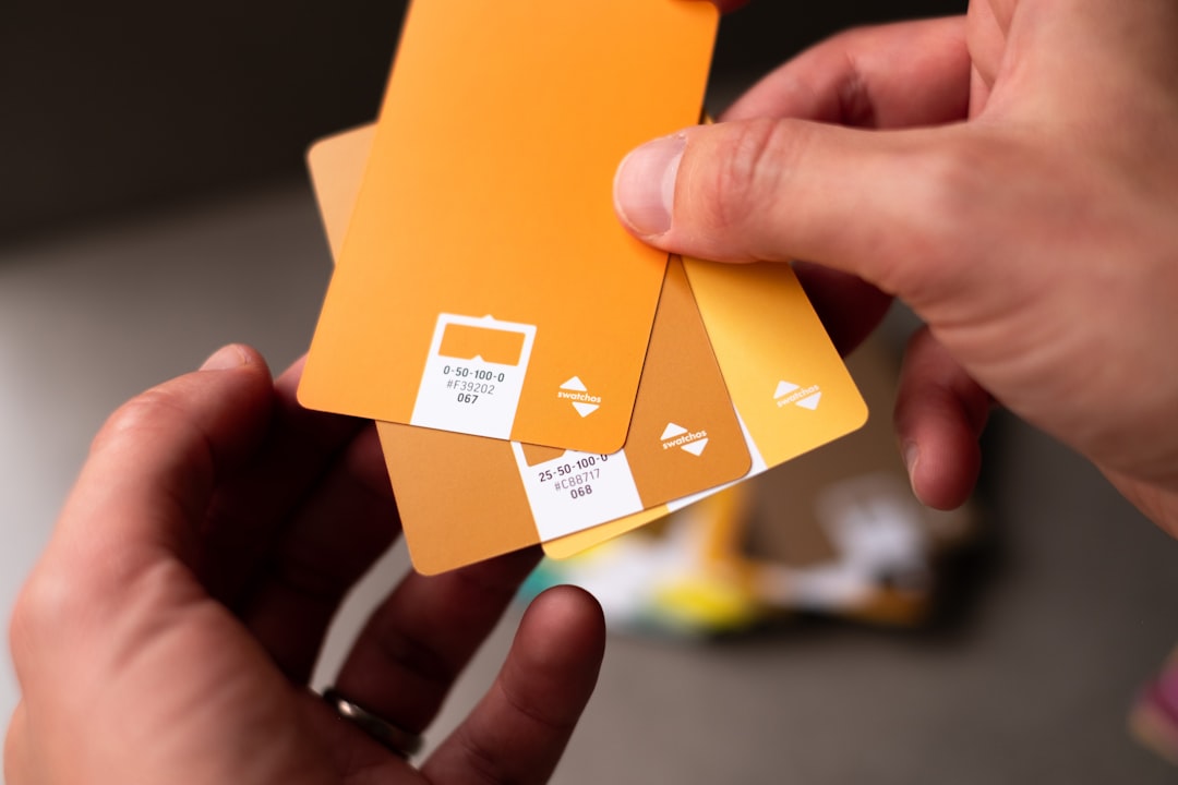 a person holding a set of orange cards