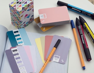 a bunch of pens and notebooks on a table