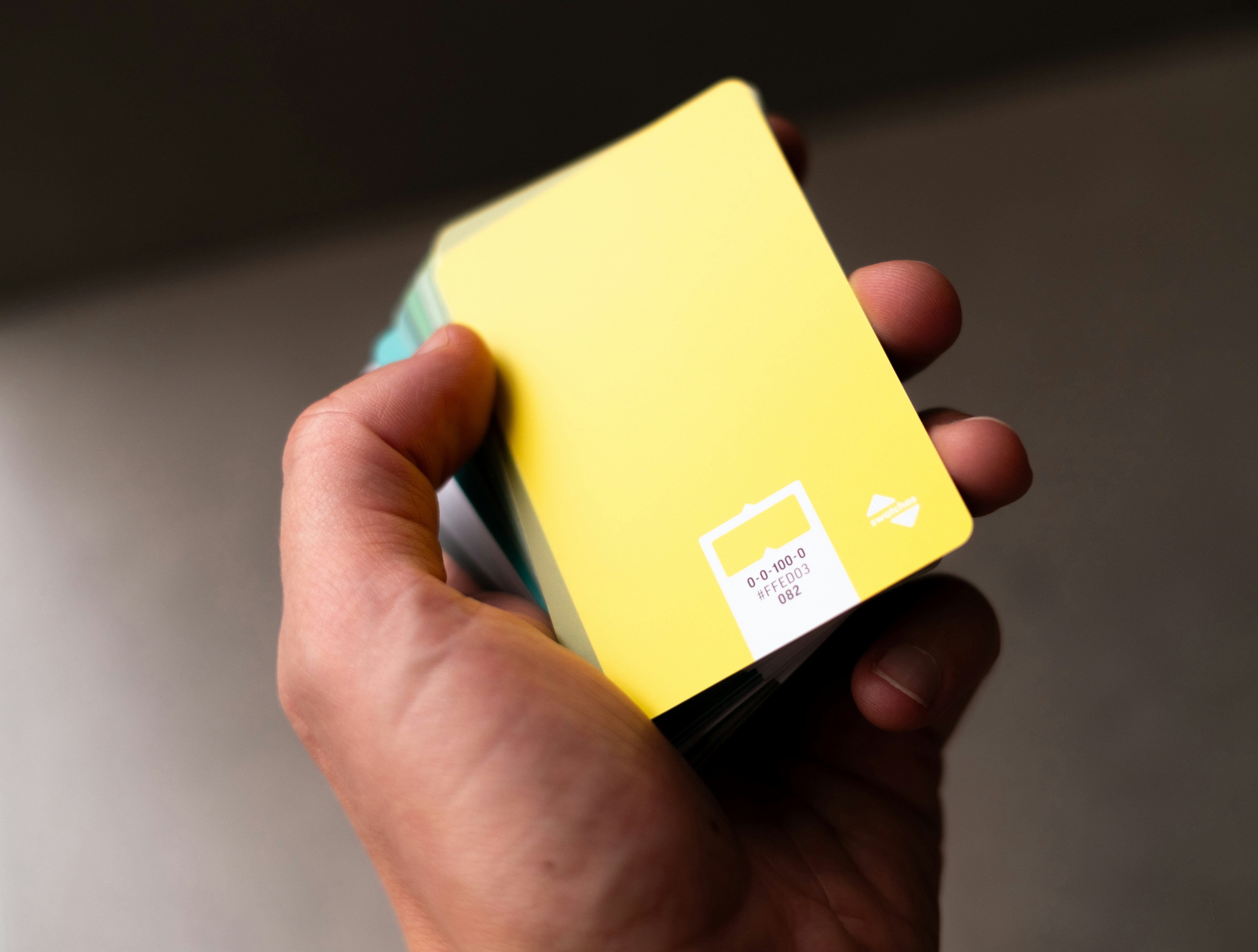 a hand holding a yellow box with a sticker on it