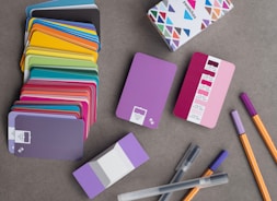 a bunch of colorful notebooks and pens on a table