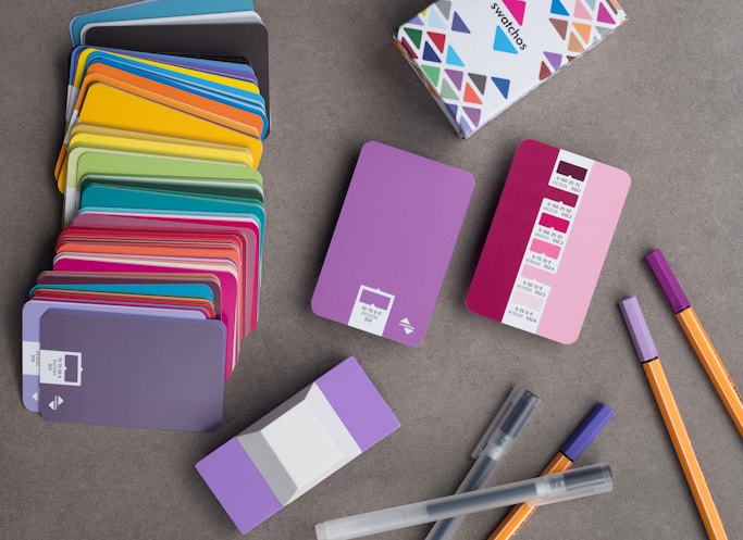 a bunch of colorful notebooks and pens on a table