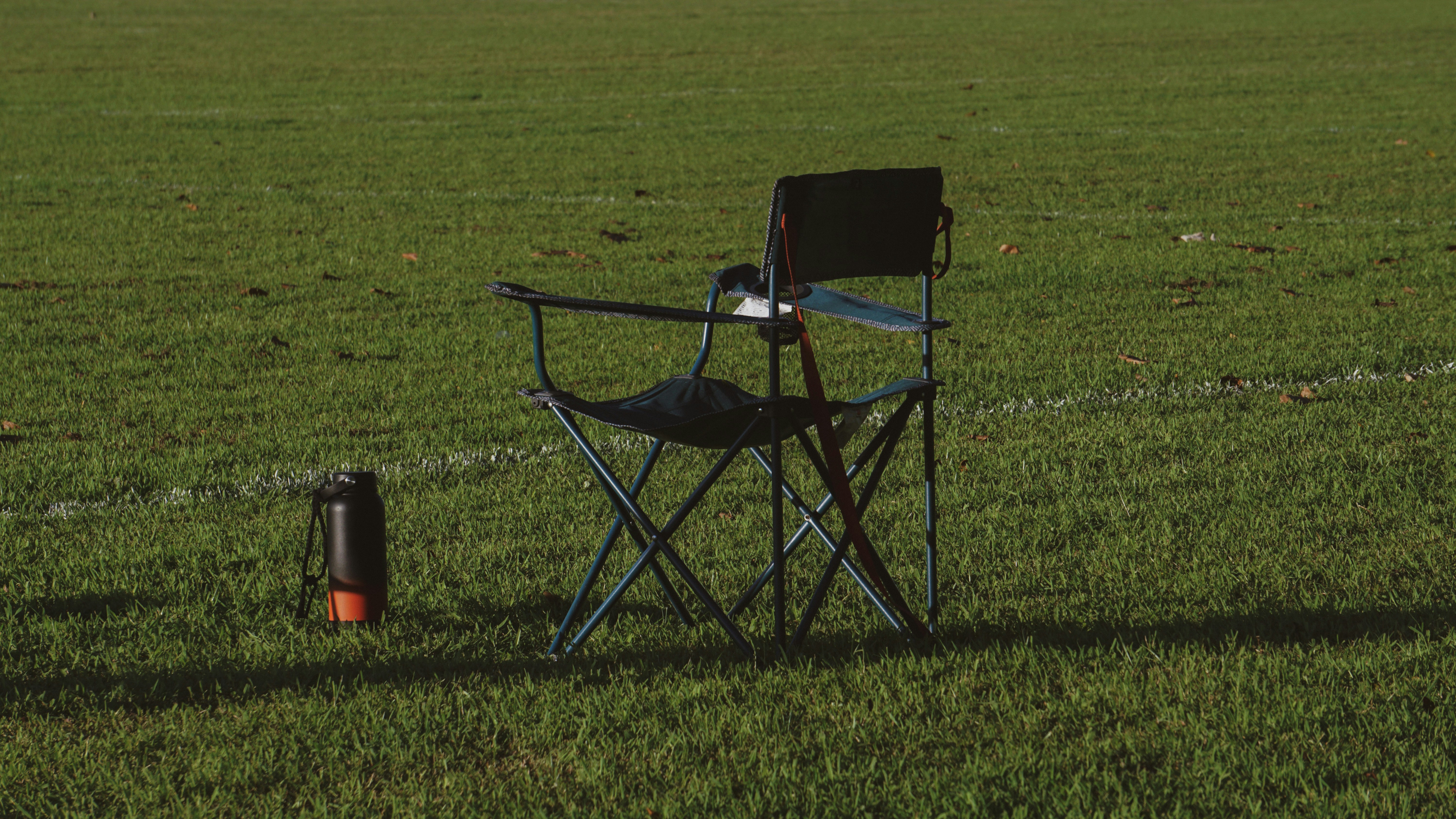 a chair and a trash can in a field