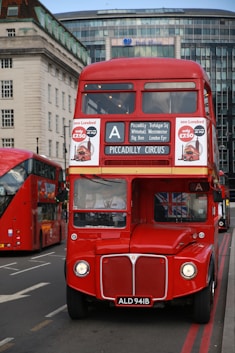 a red double decker bus driving down a street