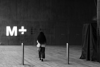 a woman standing in front of a sign that says m + m