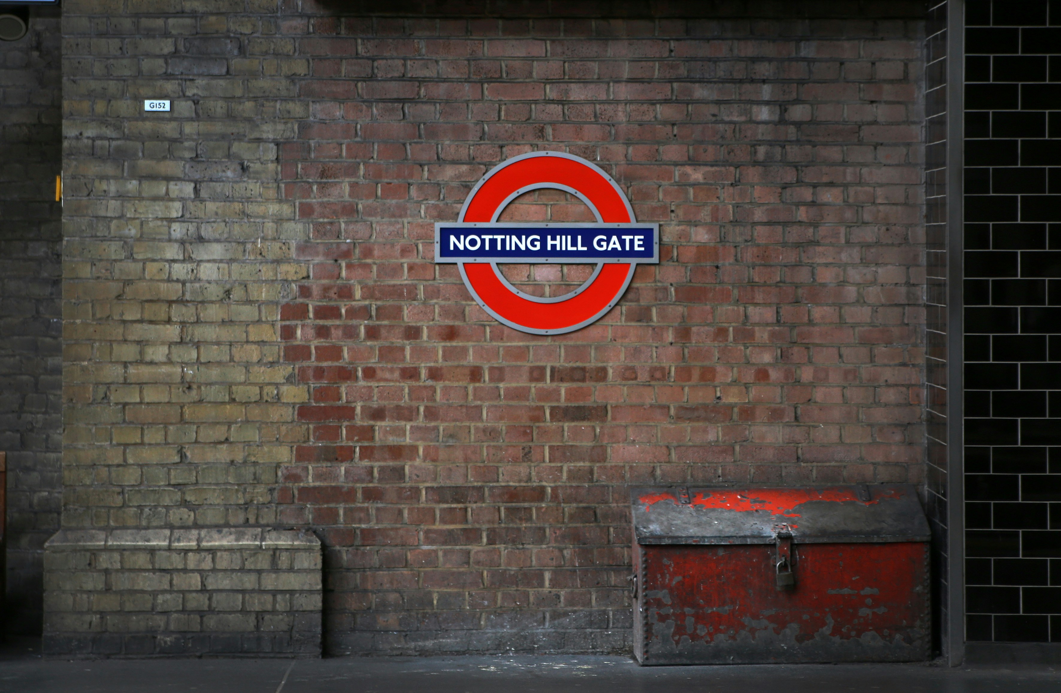 Un muro di mattoni con un cartello che dice Notting Hill Gate