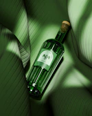 a bottle of wine sitting on top of a green couch