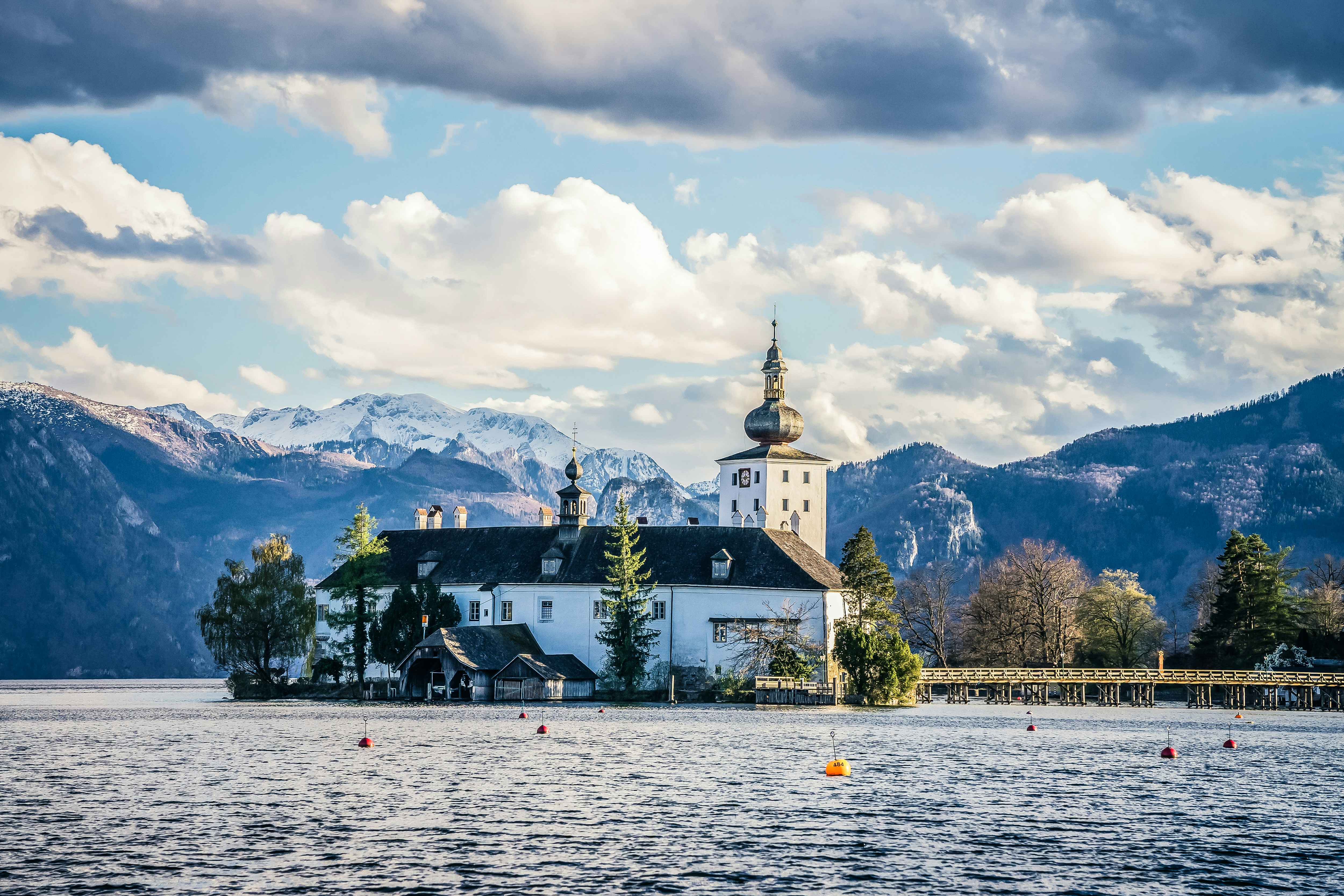 a church on a lake with mountains in the background