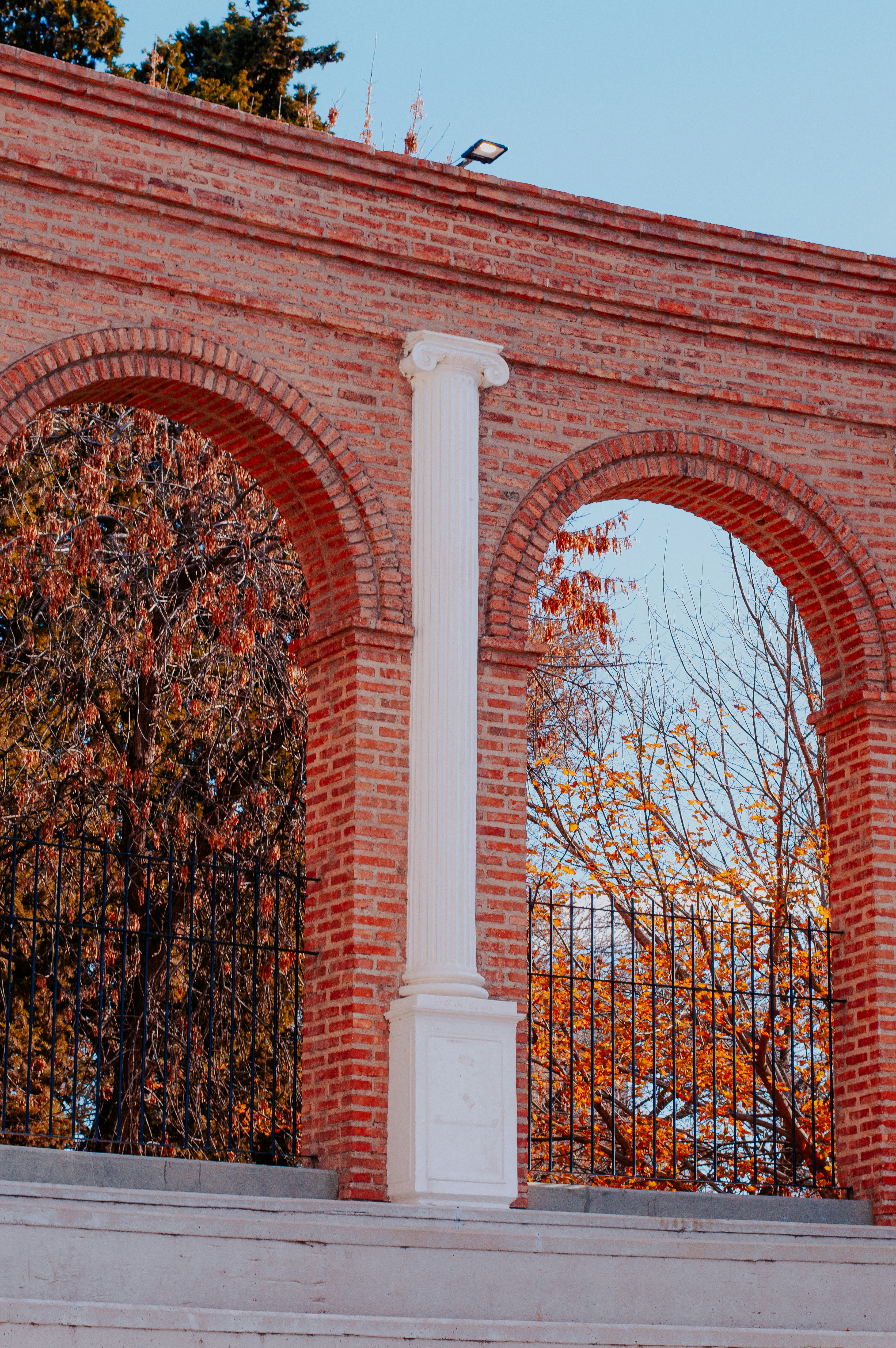 a tall white pillar sitting next to a brick wall