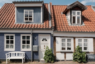 uma casa azul com um banco branco na frente