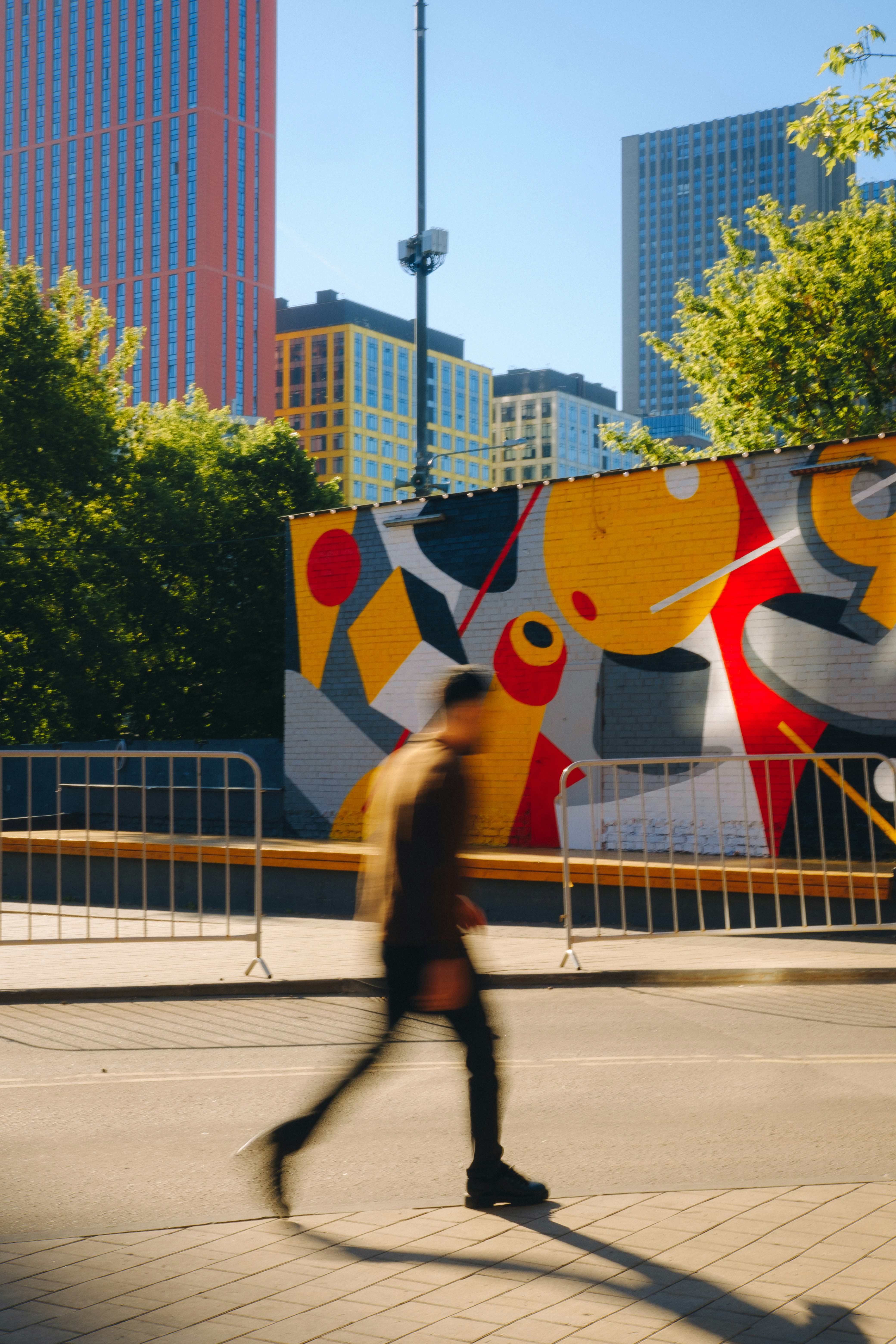 a man riding a skateboard down a street next to tall buildings