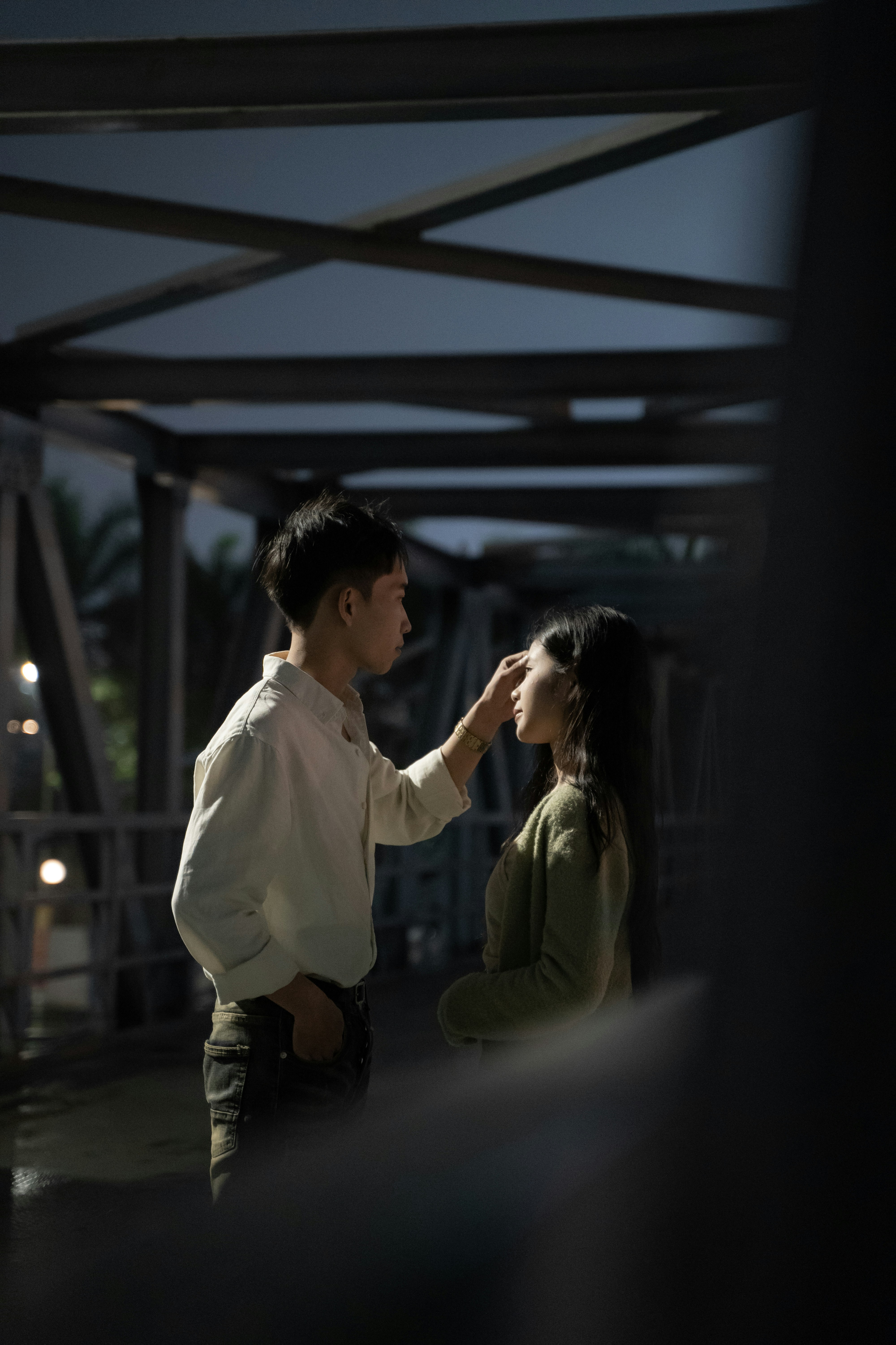 a man and a woman standing under a bridge