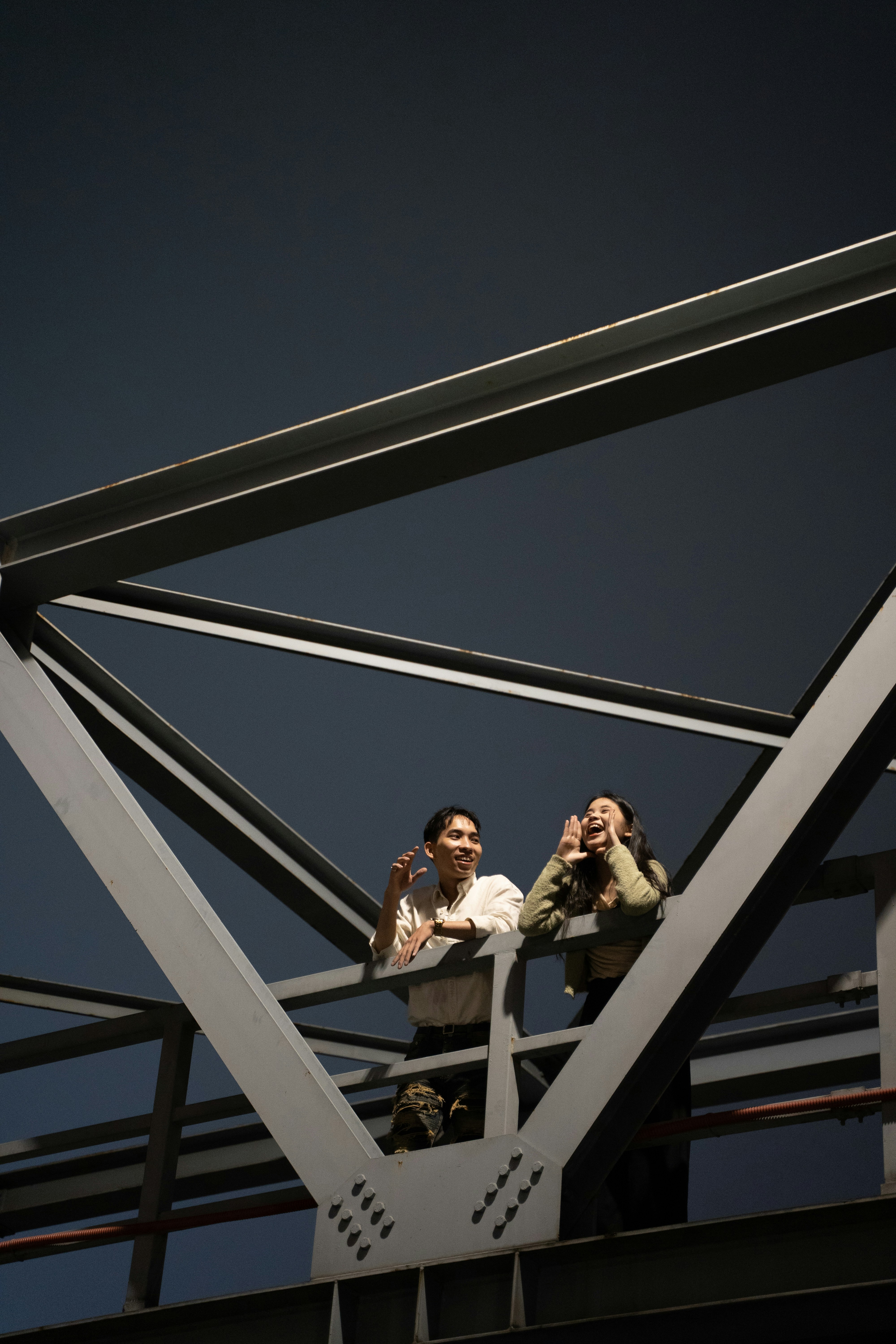 a couple of people that are standing on a bridge