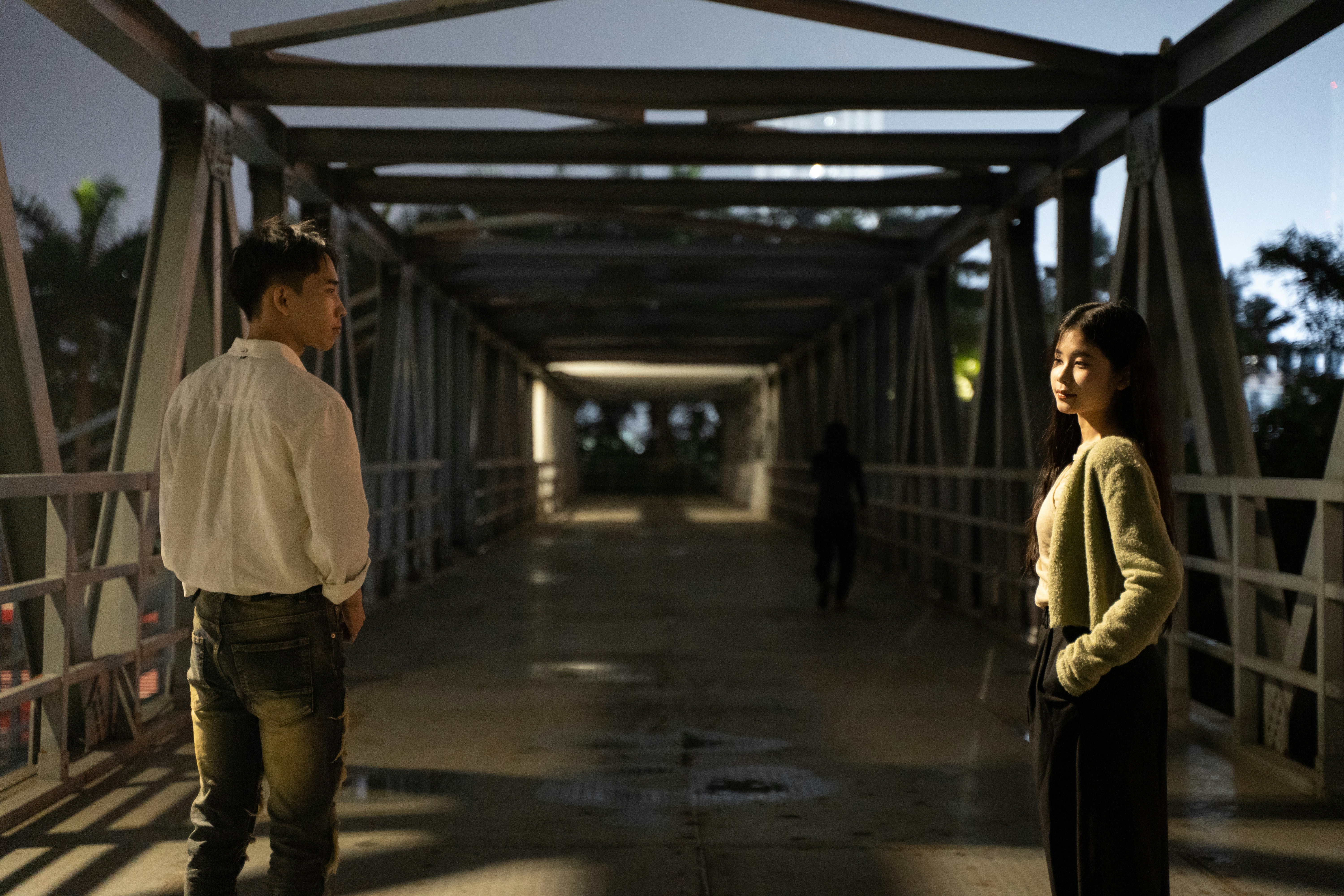a man and a woman standing on a bridge