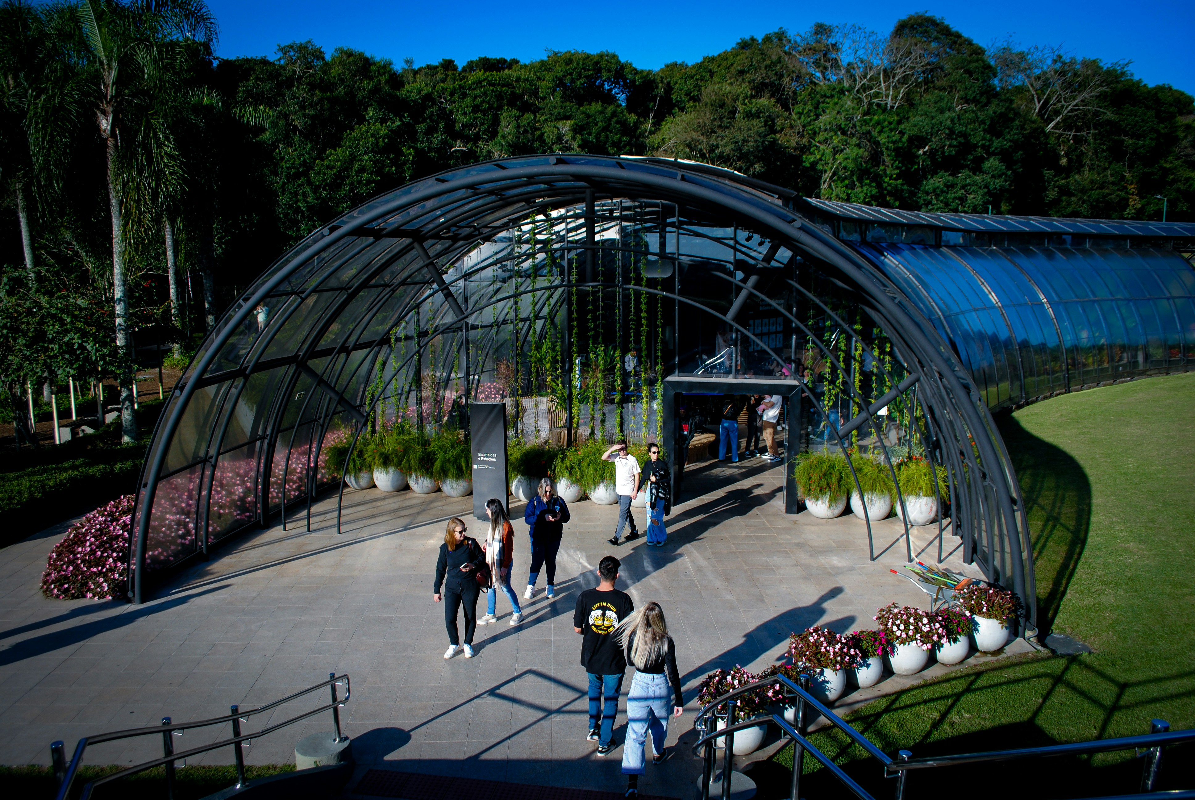 a group of people walking around a large greenhouse