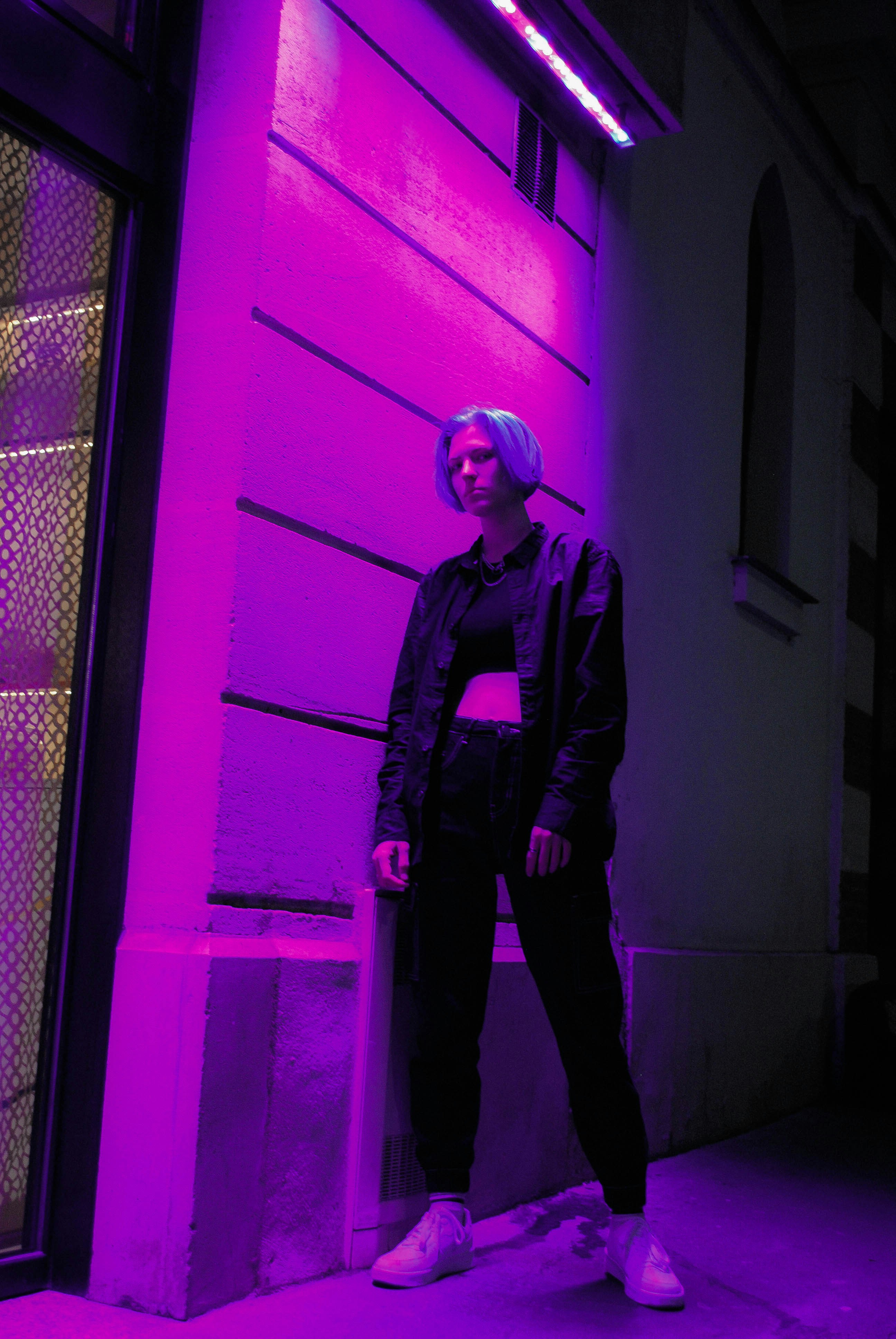 a woman standing in front of a purple wall