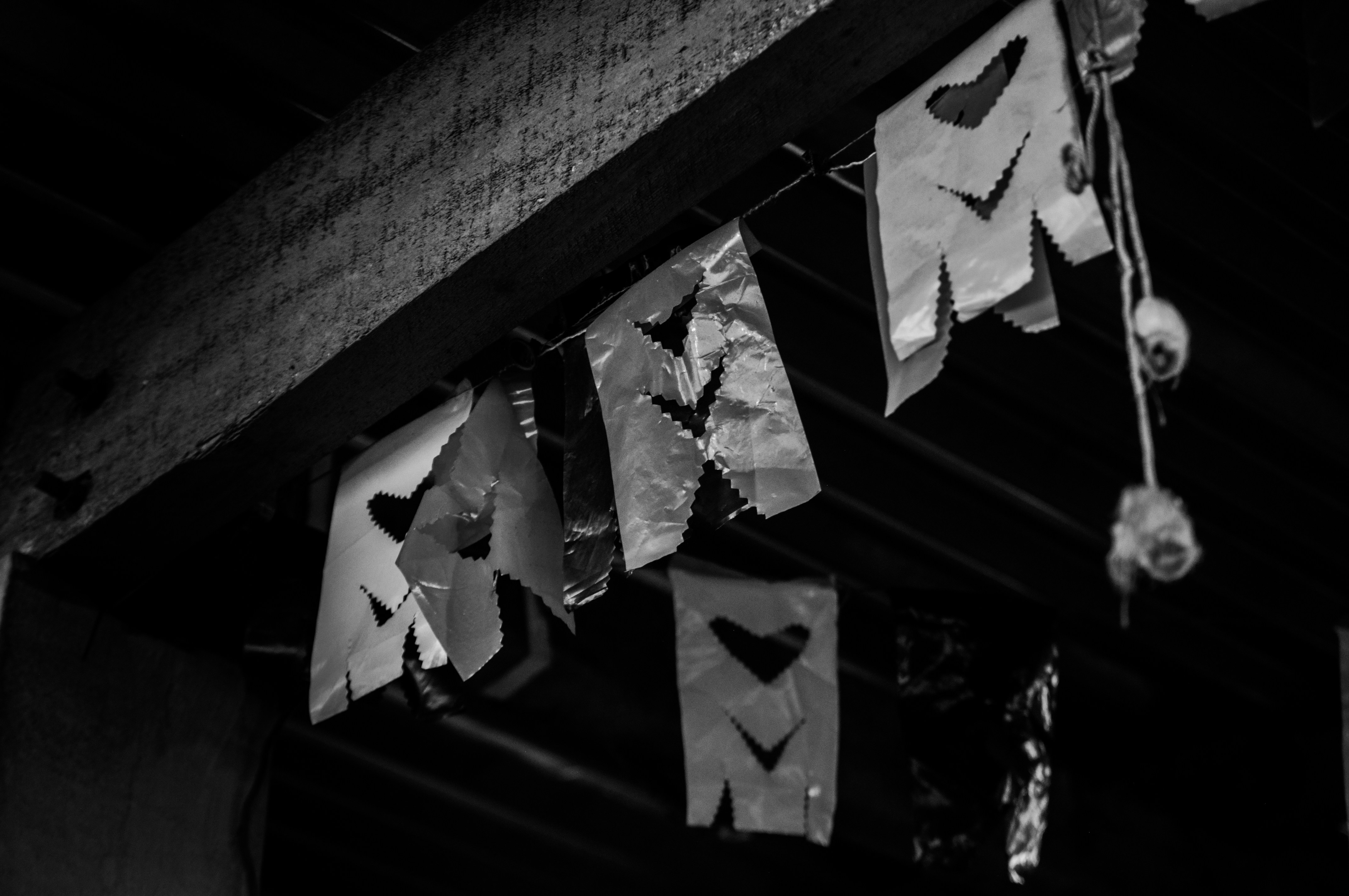 a black and white photo of paper hearts hanging from a ceiling