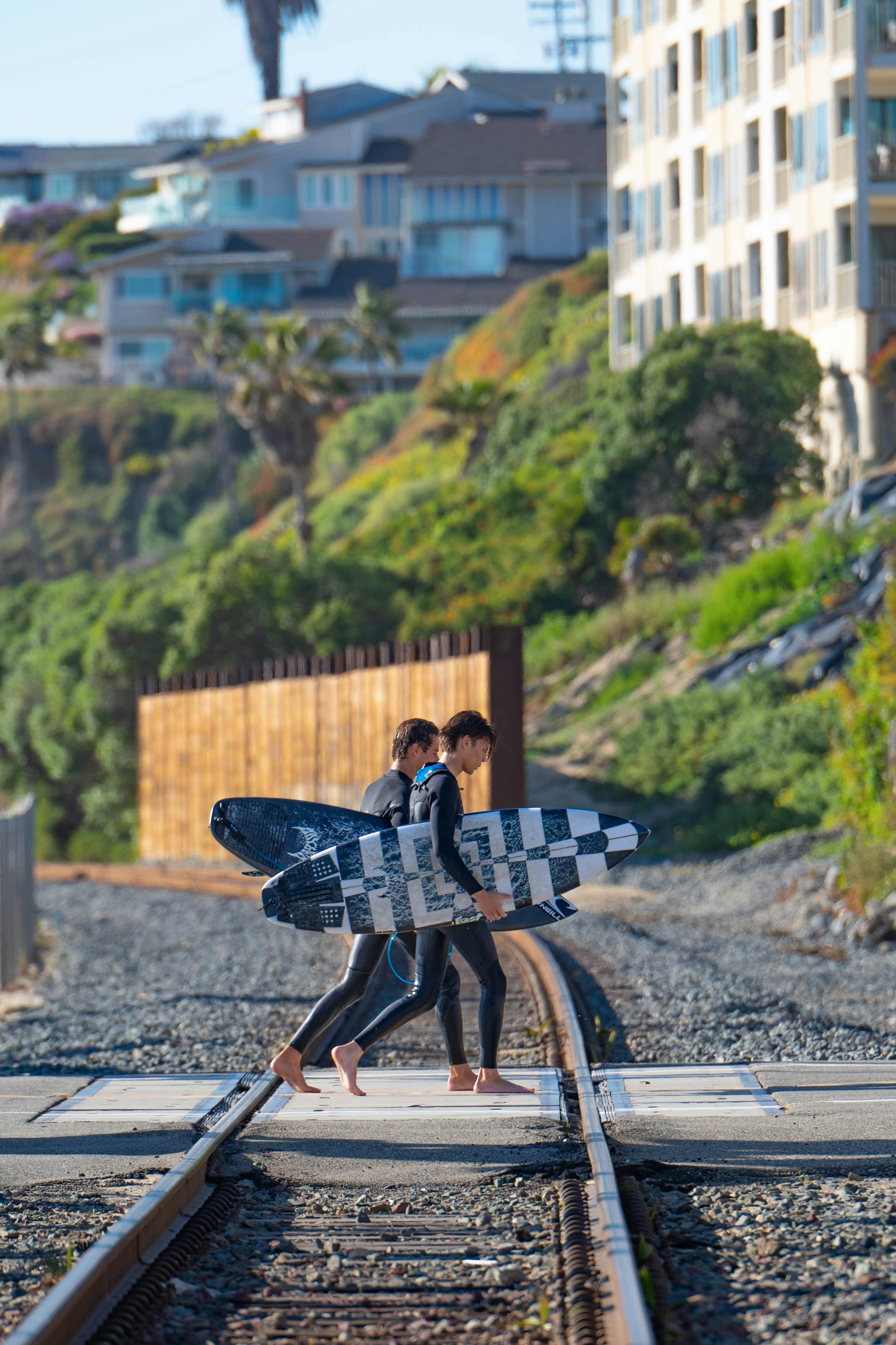 a couple of people walking across a train track