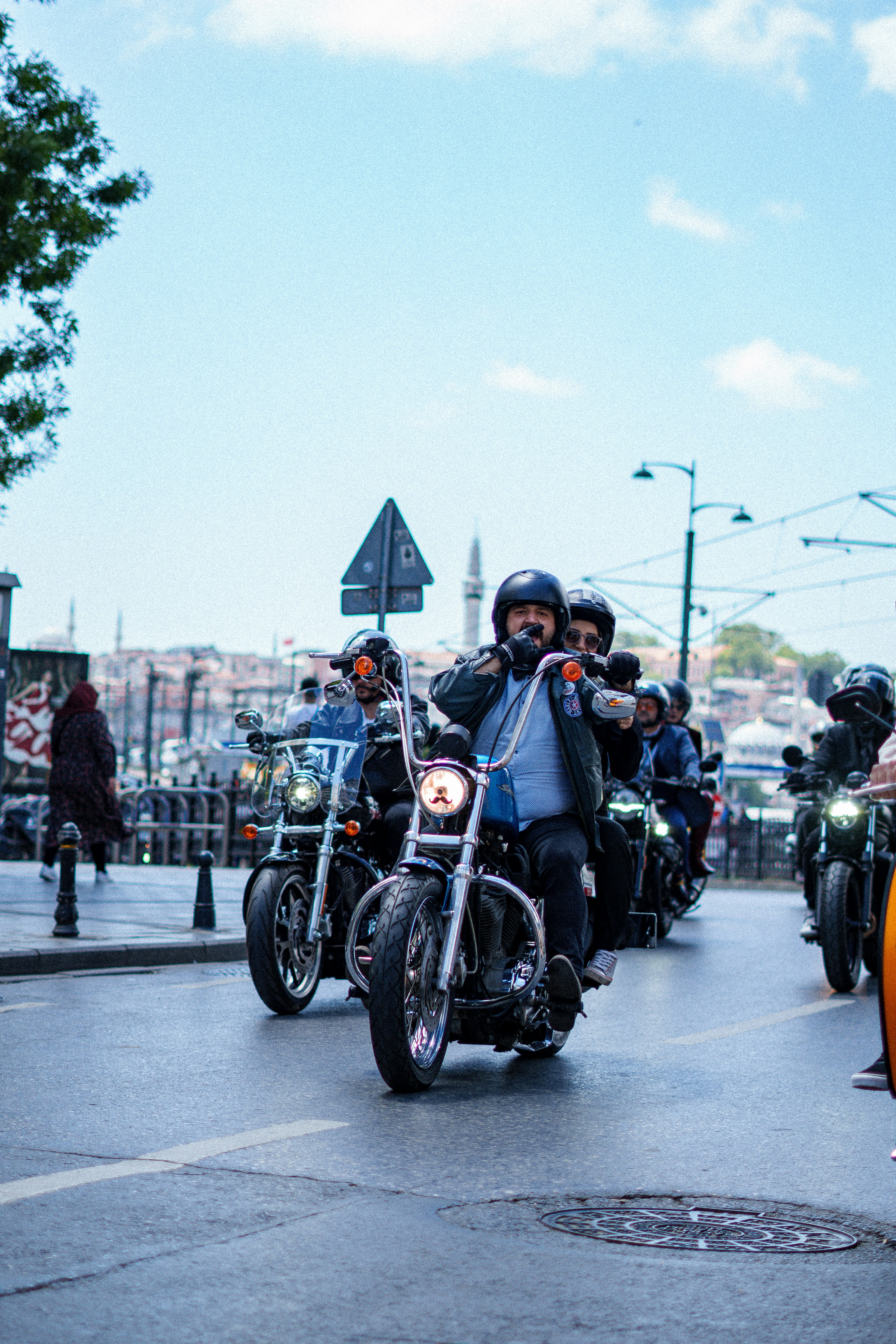 A group of people riding motorcycles down a street photo – Free ...