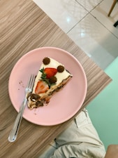 a piece of cake on a pink plate with a fork