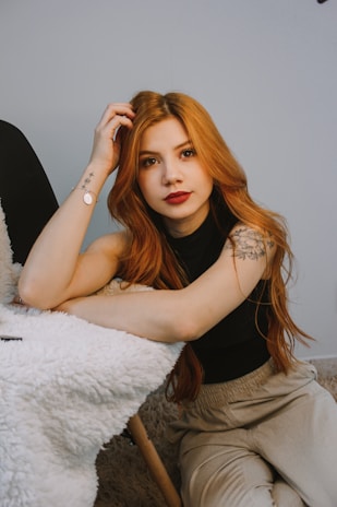 a woman with red hair sitting on the floor