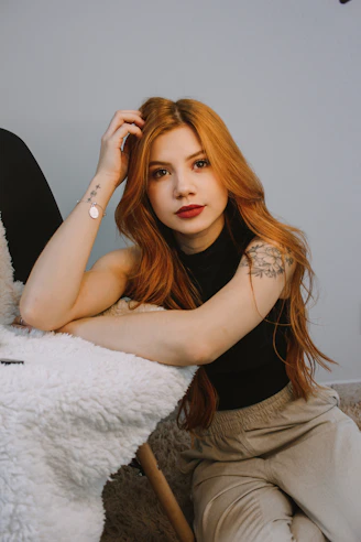 a woman with red hair sitting on the floor