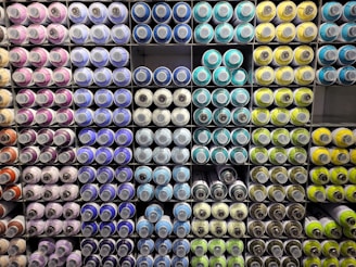 a large display of different colored spools of paint