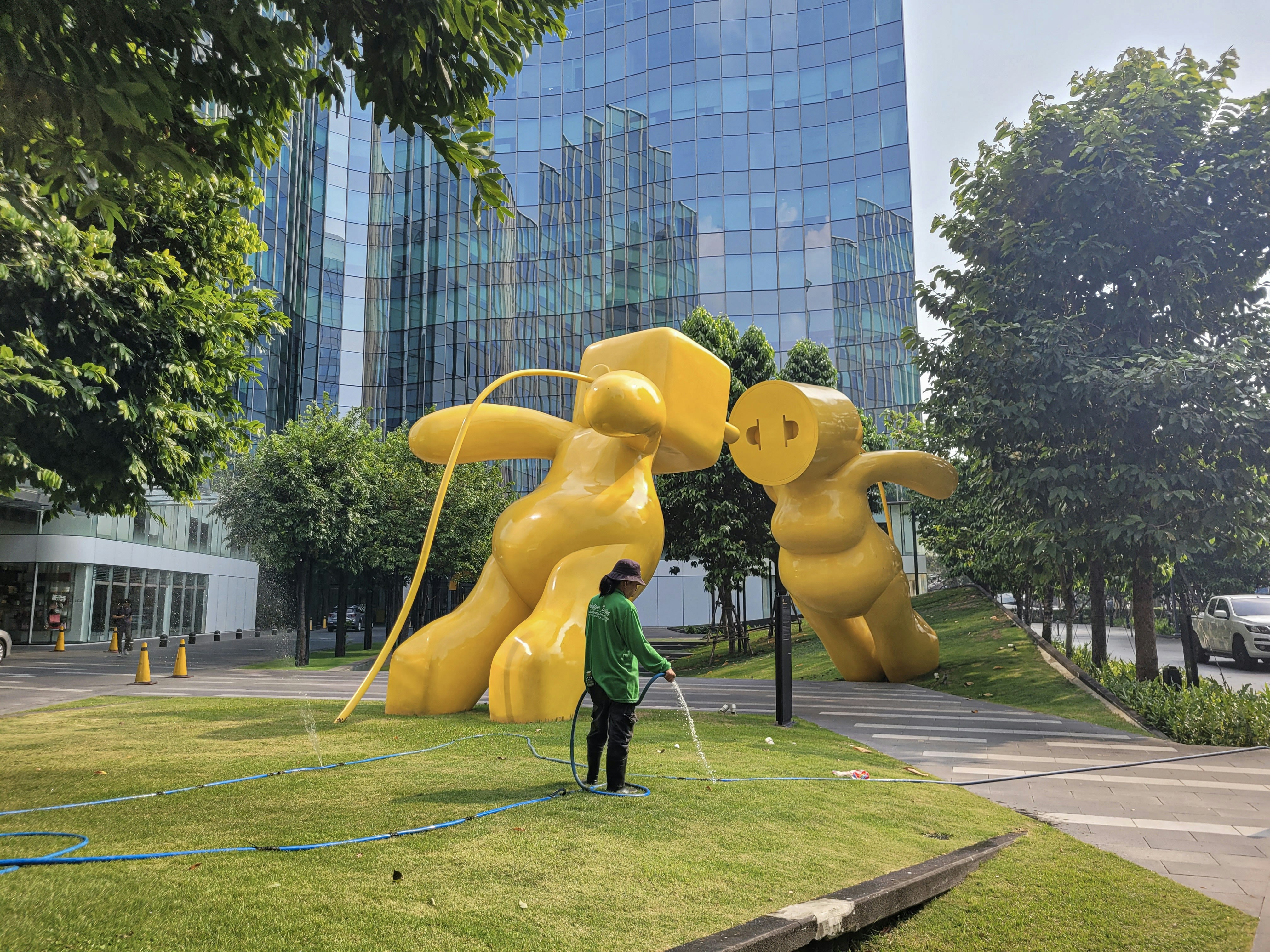 a man standing in front of a large yellow sculpture