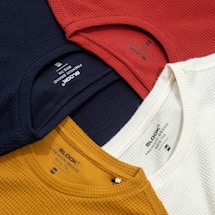a bunch of different colored shirts on a table