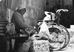 a man sitting on a bench next to a bike