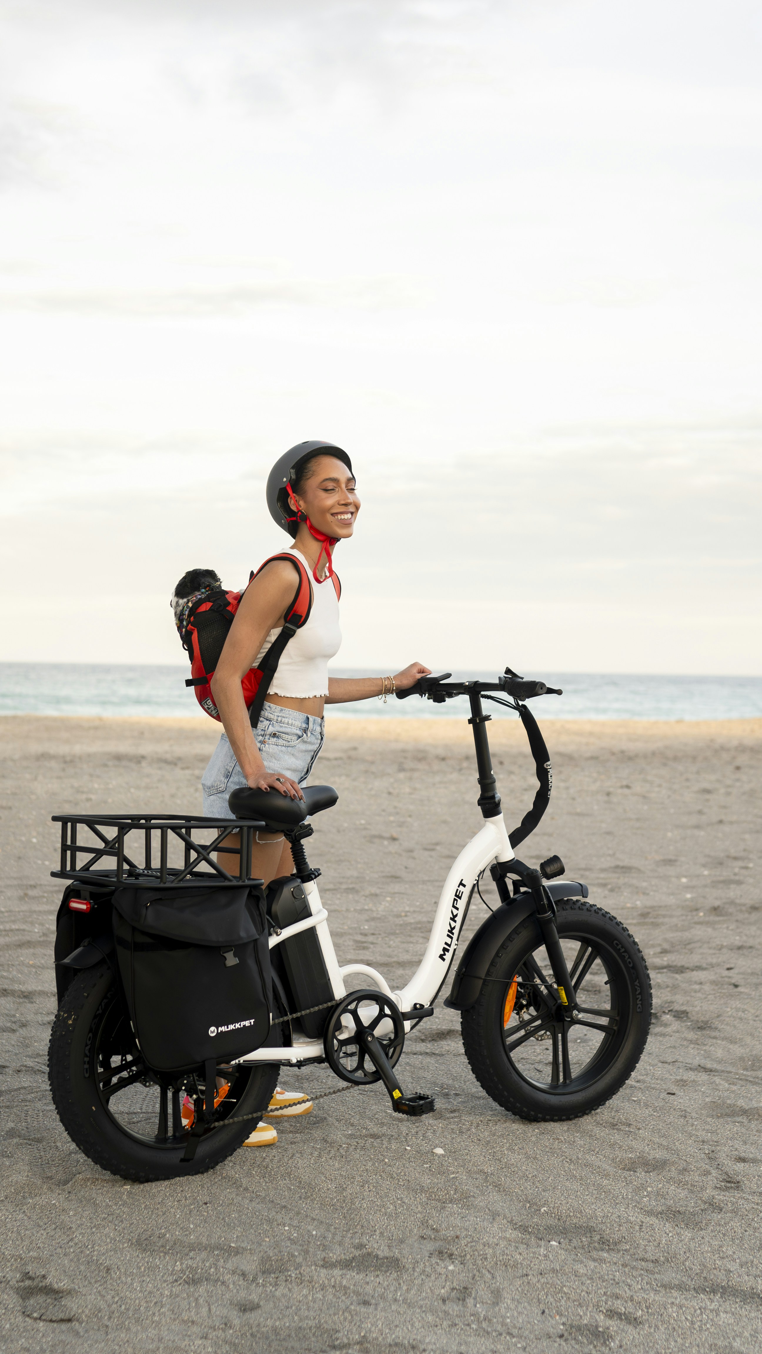 a woman is riding a bike on the beach