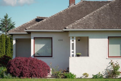 a white house with red trim and a brown roof